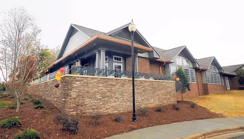 Exterior view of Trellis Supportive Care building with brick wall, porch, and balloons.