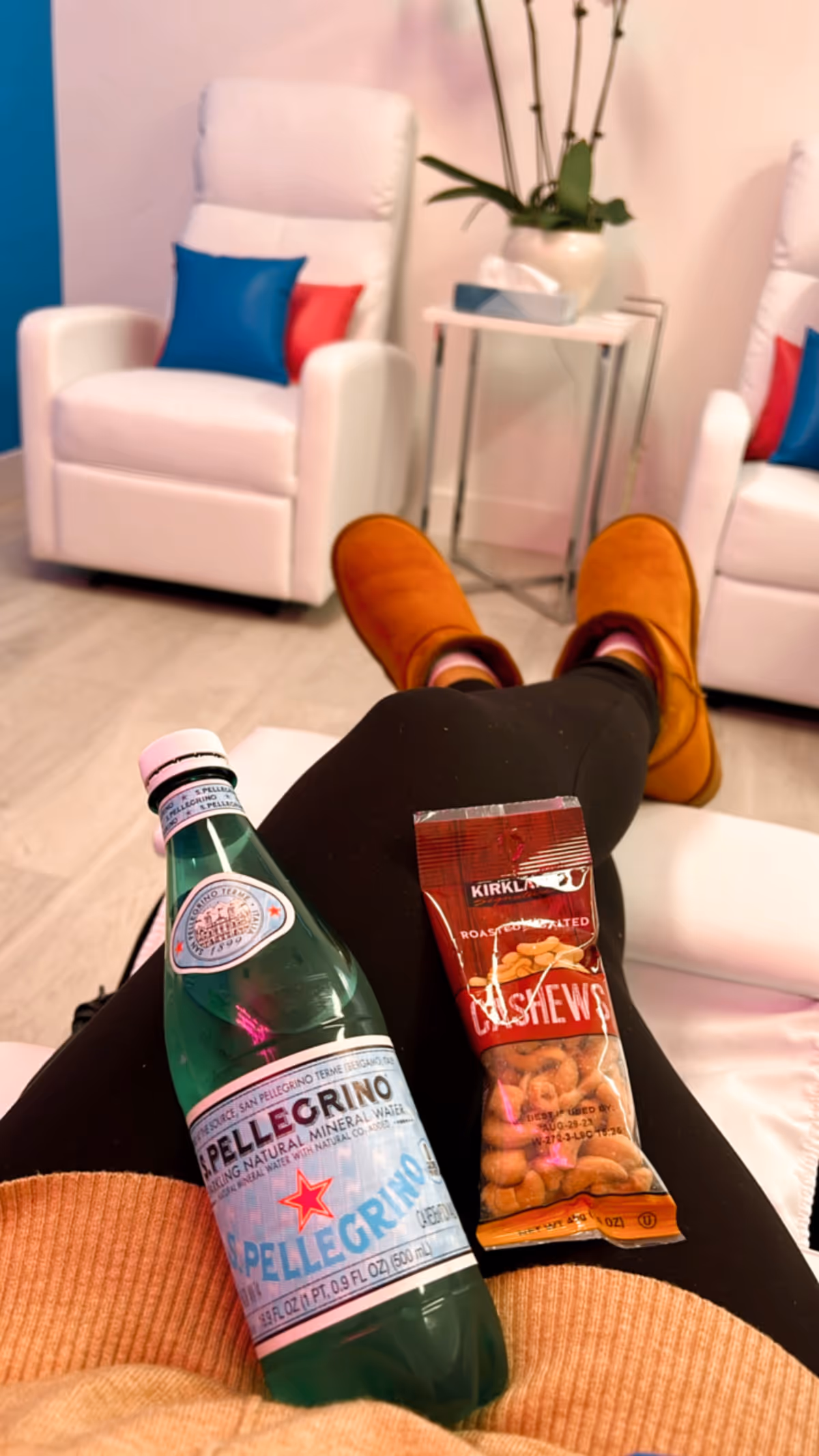 Feet propped up with water and cashews in a modern senior lounge.