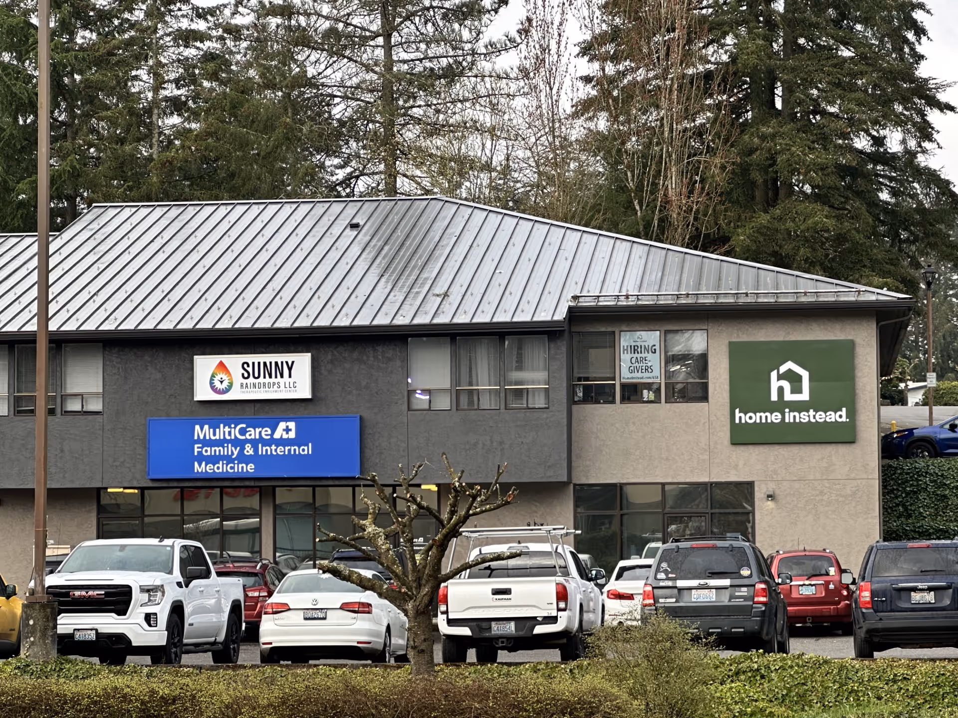 Front exterior of a building with Home Instead sign and parked cars