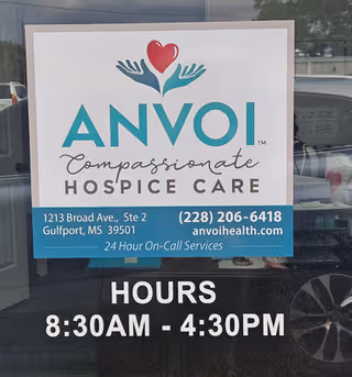 Glass-door sign for Anvoi Hospice, displaying hours and contact details.