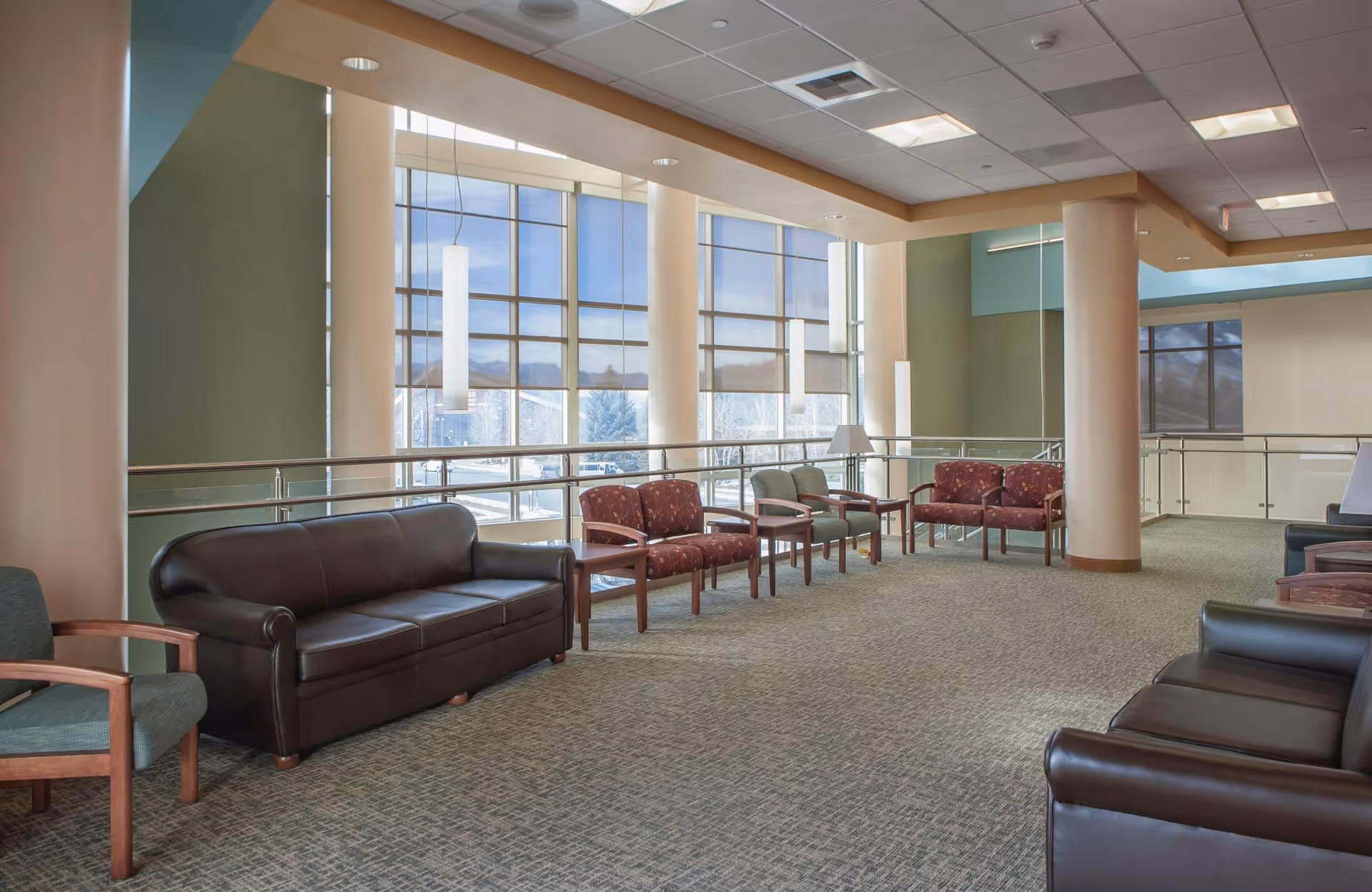 A spacious lounge area in West Park Hospital senior living facility with couches and large windows.