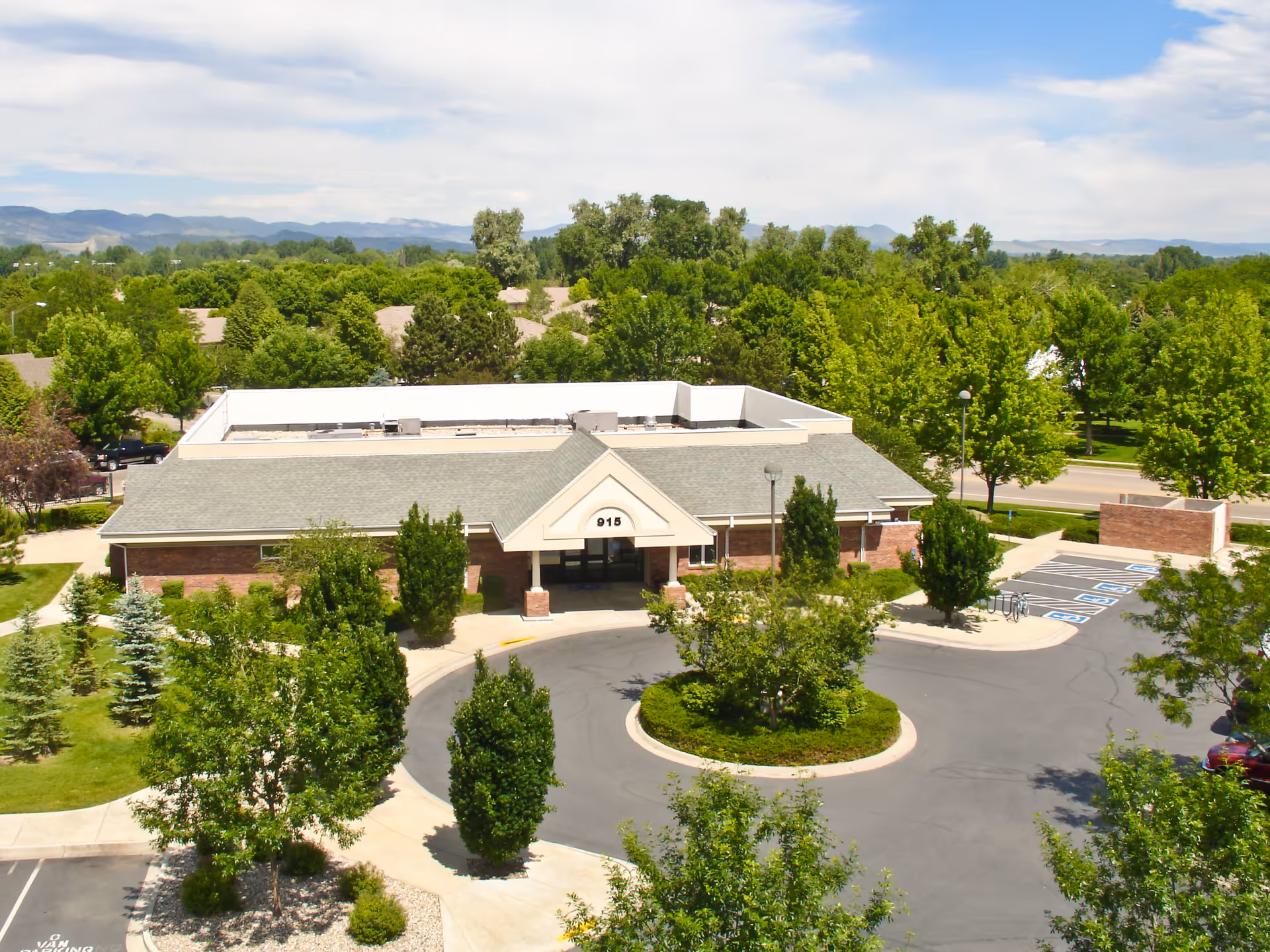 Aerial view of a senior living facility with circular driveway and green surroundings.