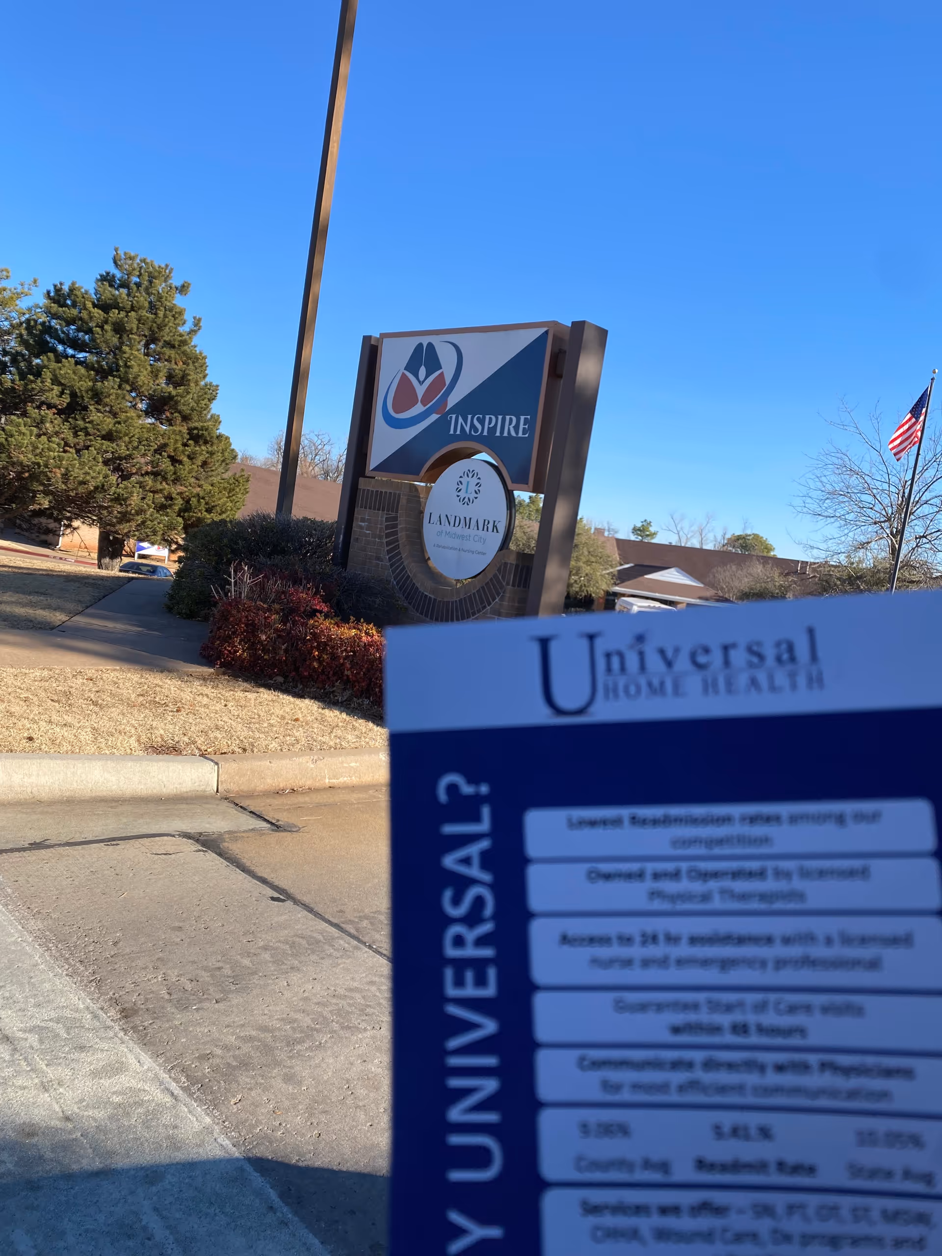 Outdoor view of a Universal Home Health facility sign with landscaping, flag, and blue sky.