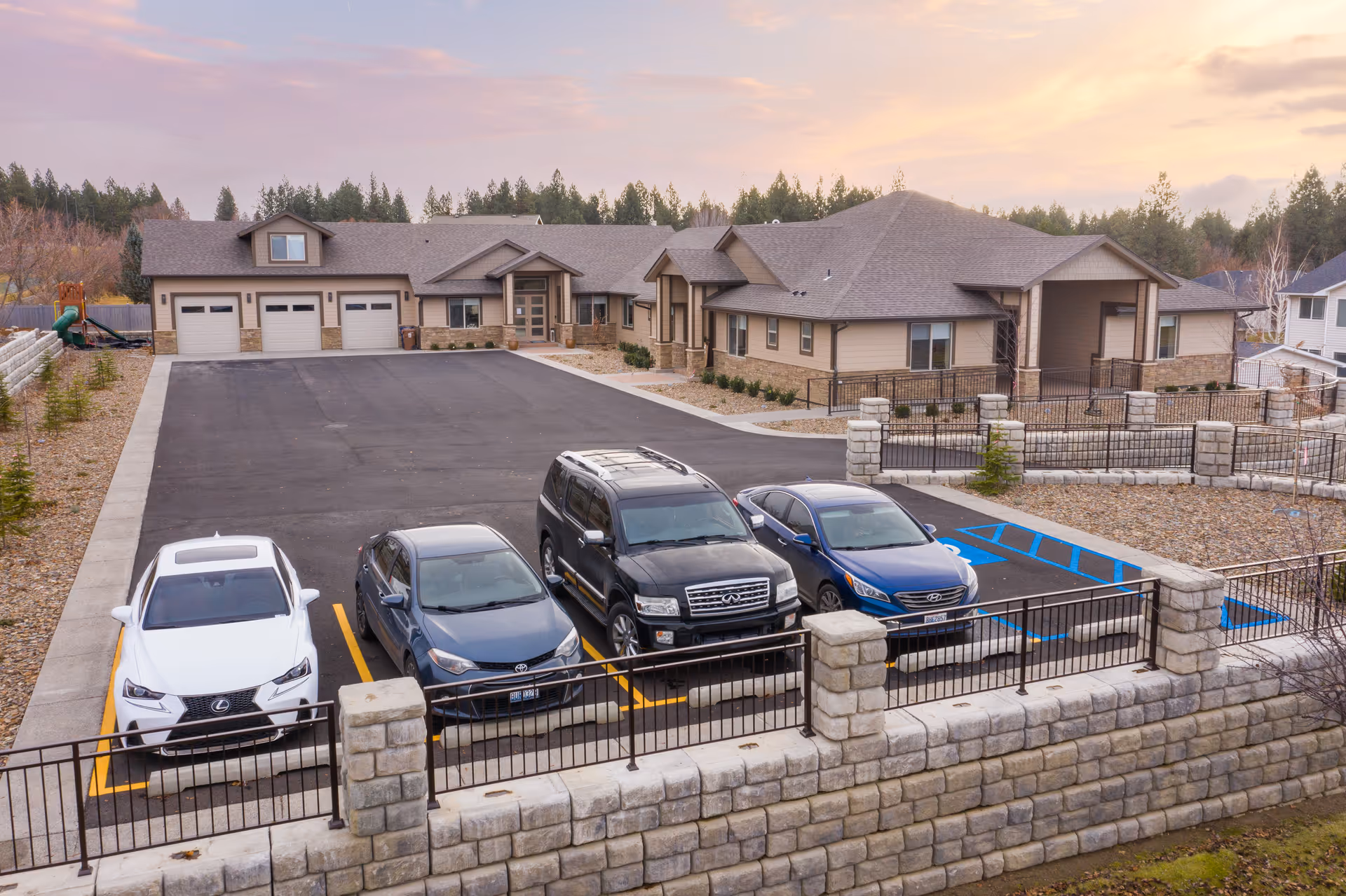 Exterior view of Providence Senior Home facility with a parking lot and cars.