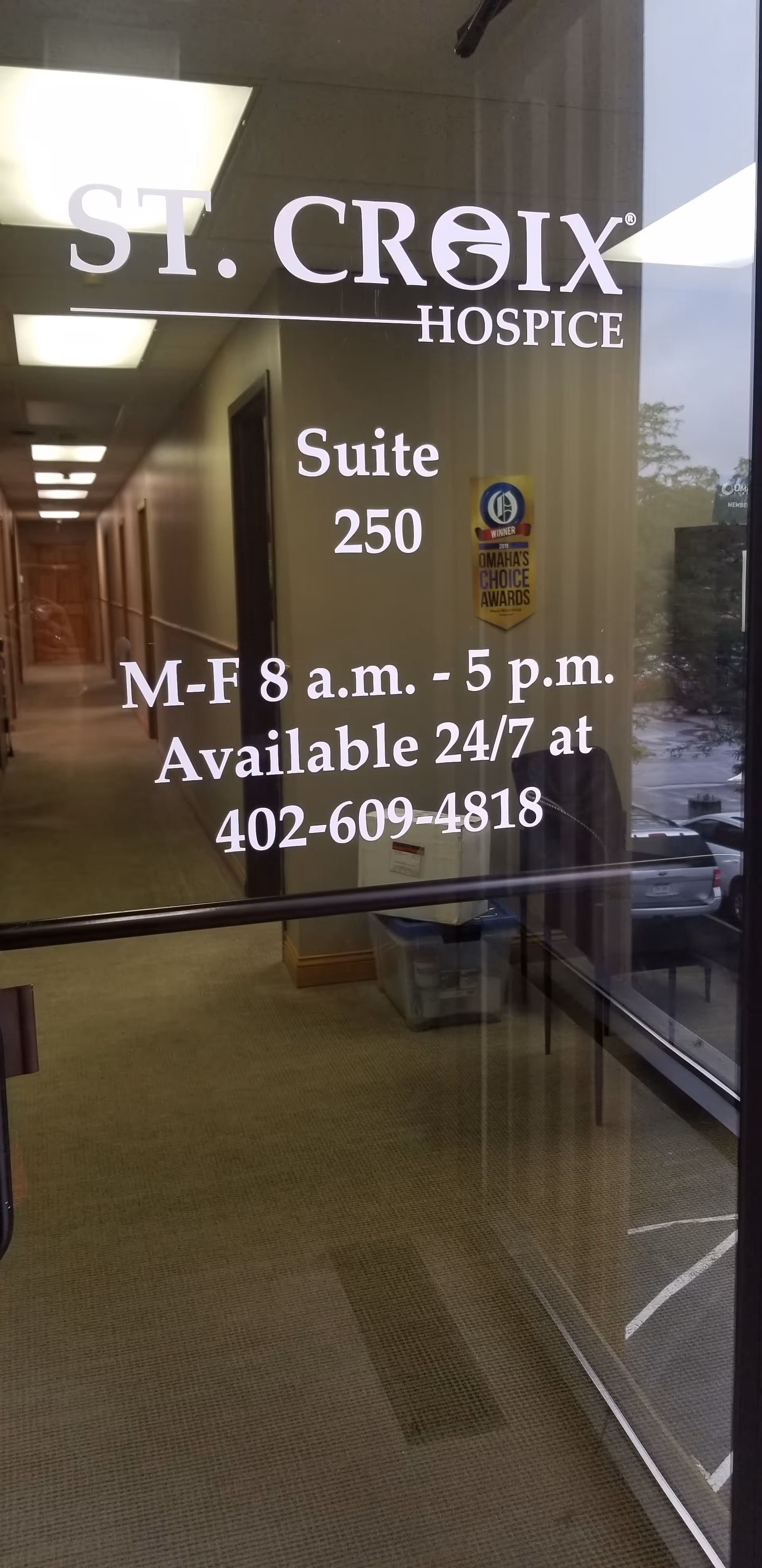 Glass door displays St. Croix Hospice signage, revealing a corridor inside the facility.
