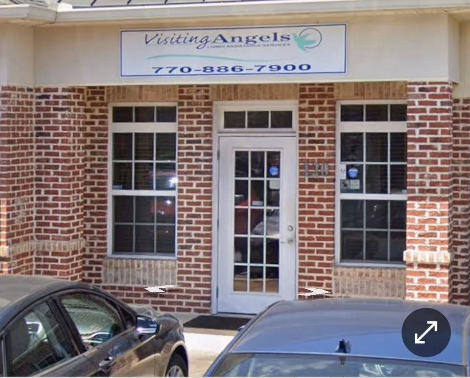 Exterior view of Visiting Angels Senior Home Care building with brick facade and parked cars.