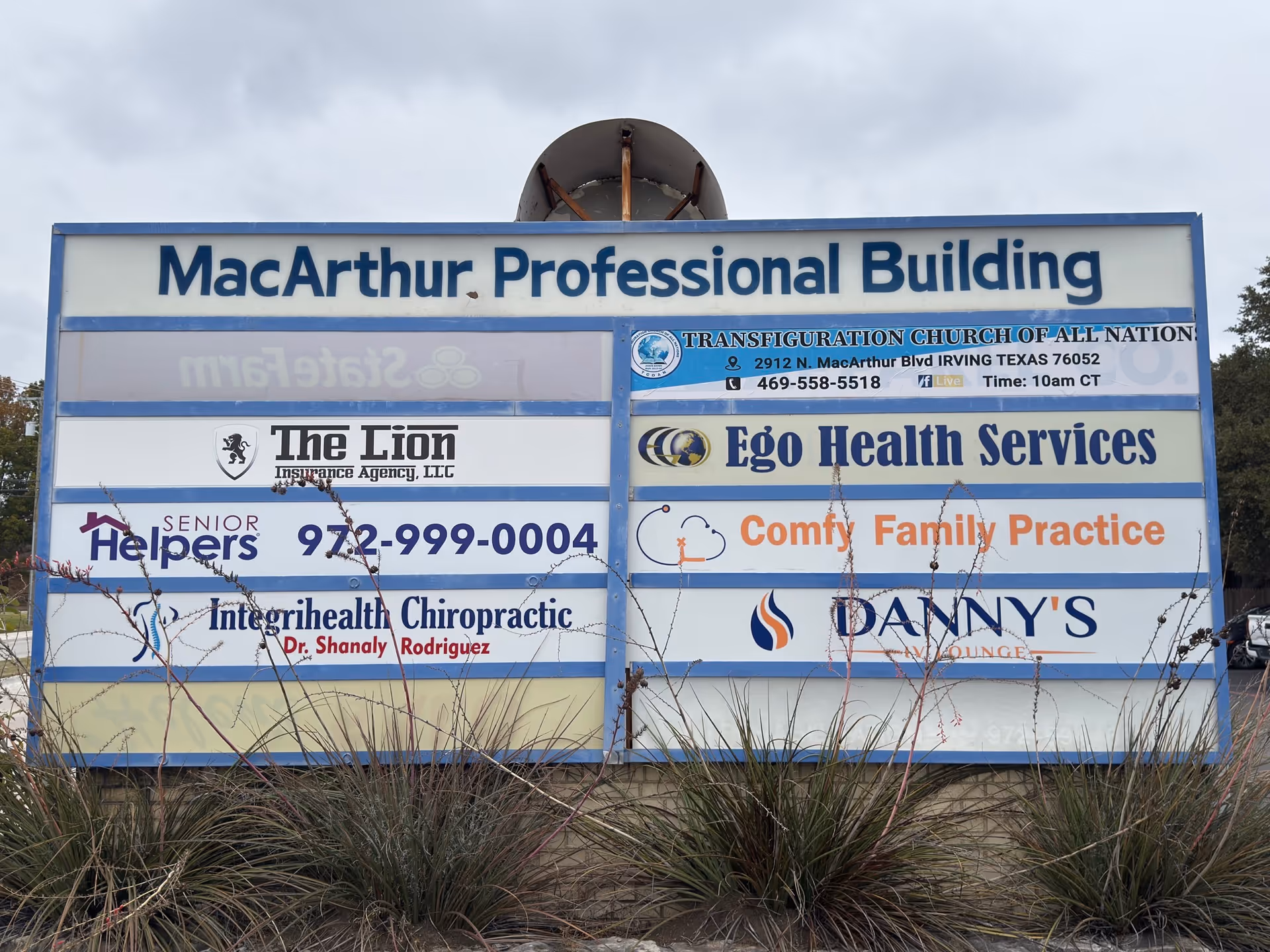 Large outdoor building signboard listing Senior Helpers alongside other tenants.