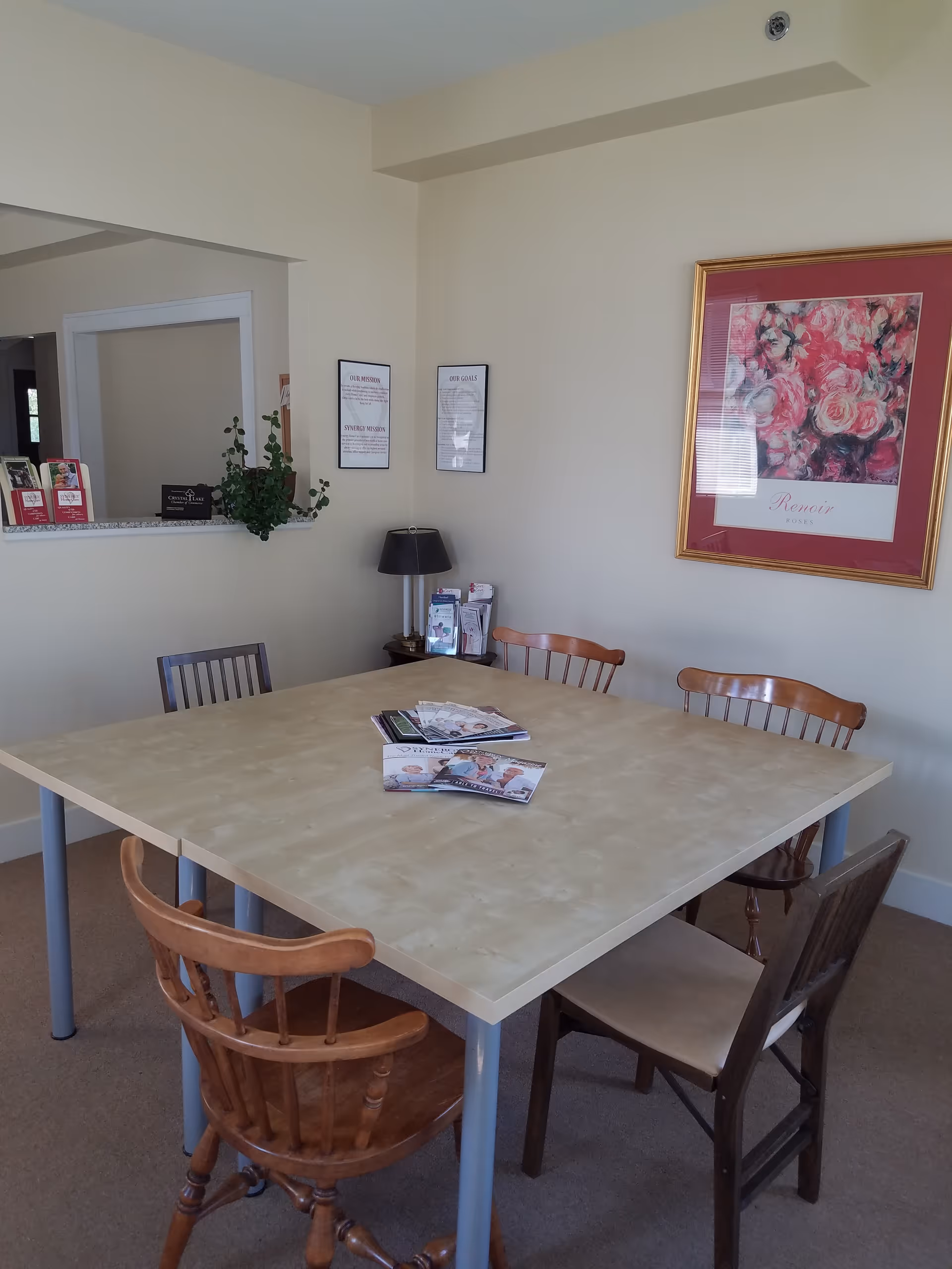 A communal dining room with a large table and wall art.