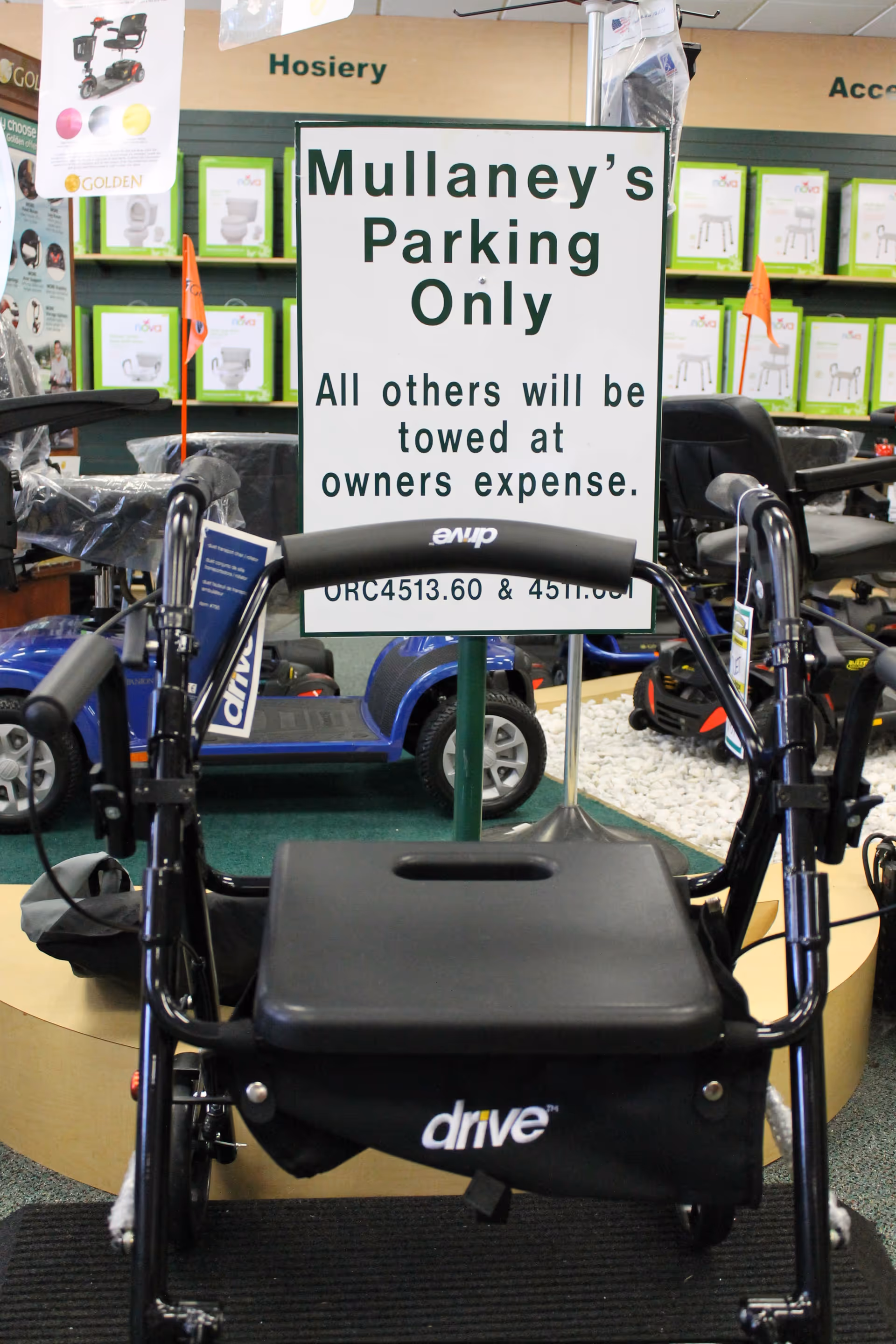 Interior showroom with mobility scooters and a large Mullaney's Parking Only sign.