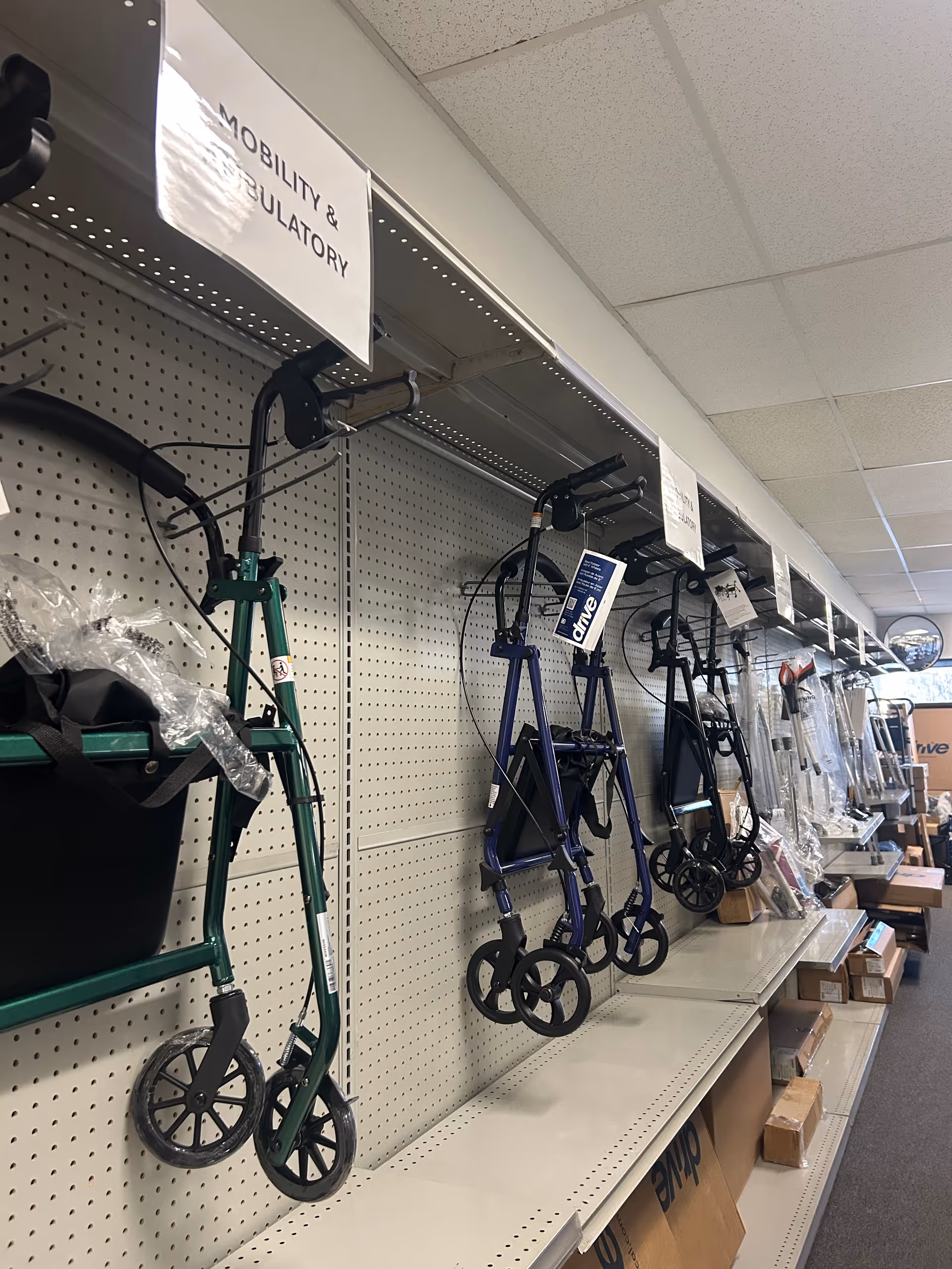 Row of walkers displayed on a pegboard wall inside a medical supply store.