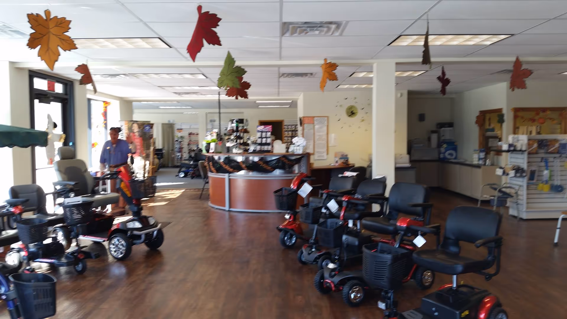 Interior of Mobility Plus showroom with mobility scooters and a reception desk.