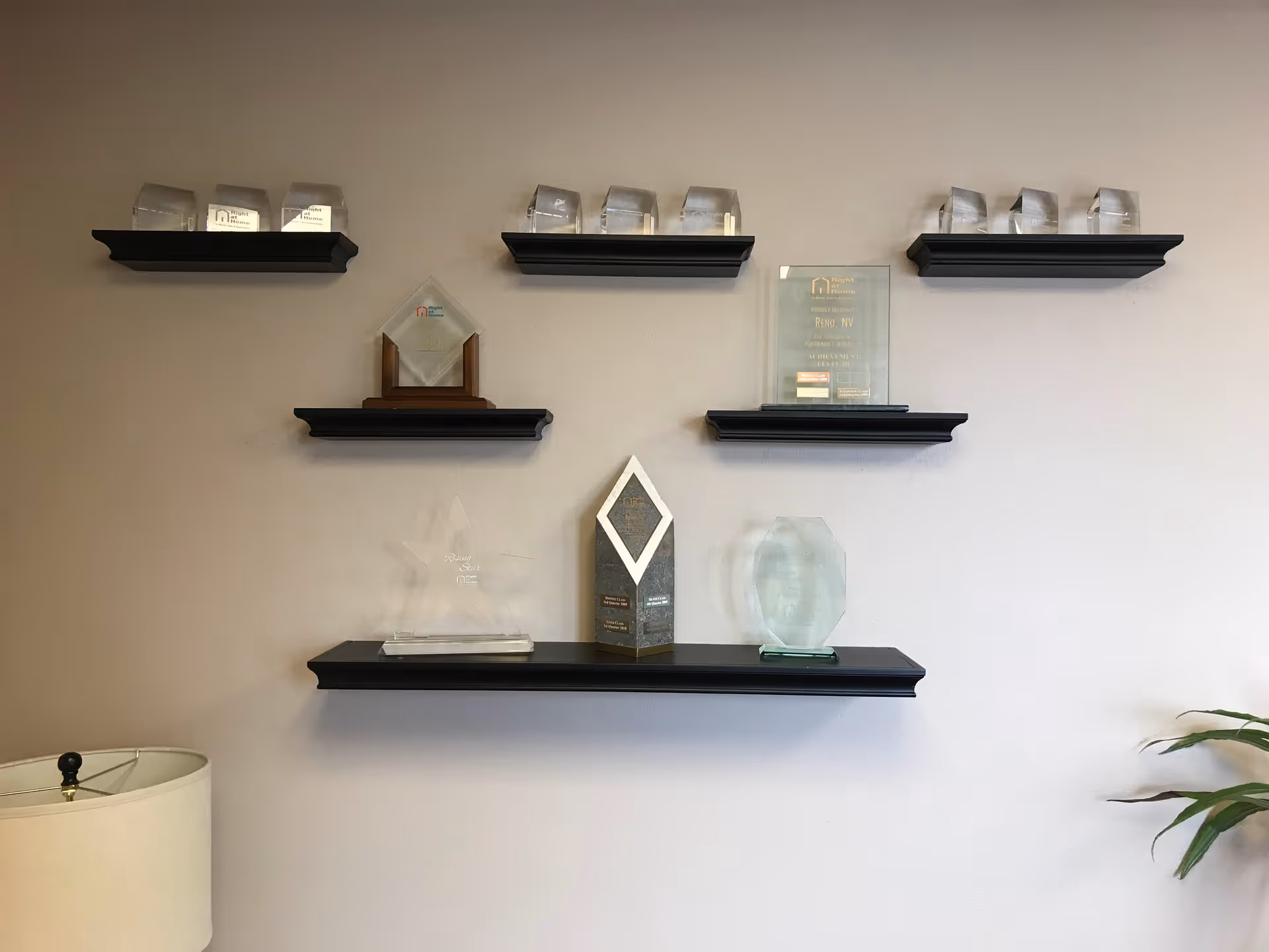 Interior wall with black shelves displaying awards and glass plaques
