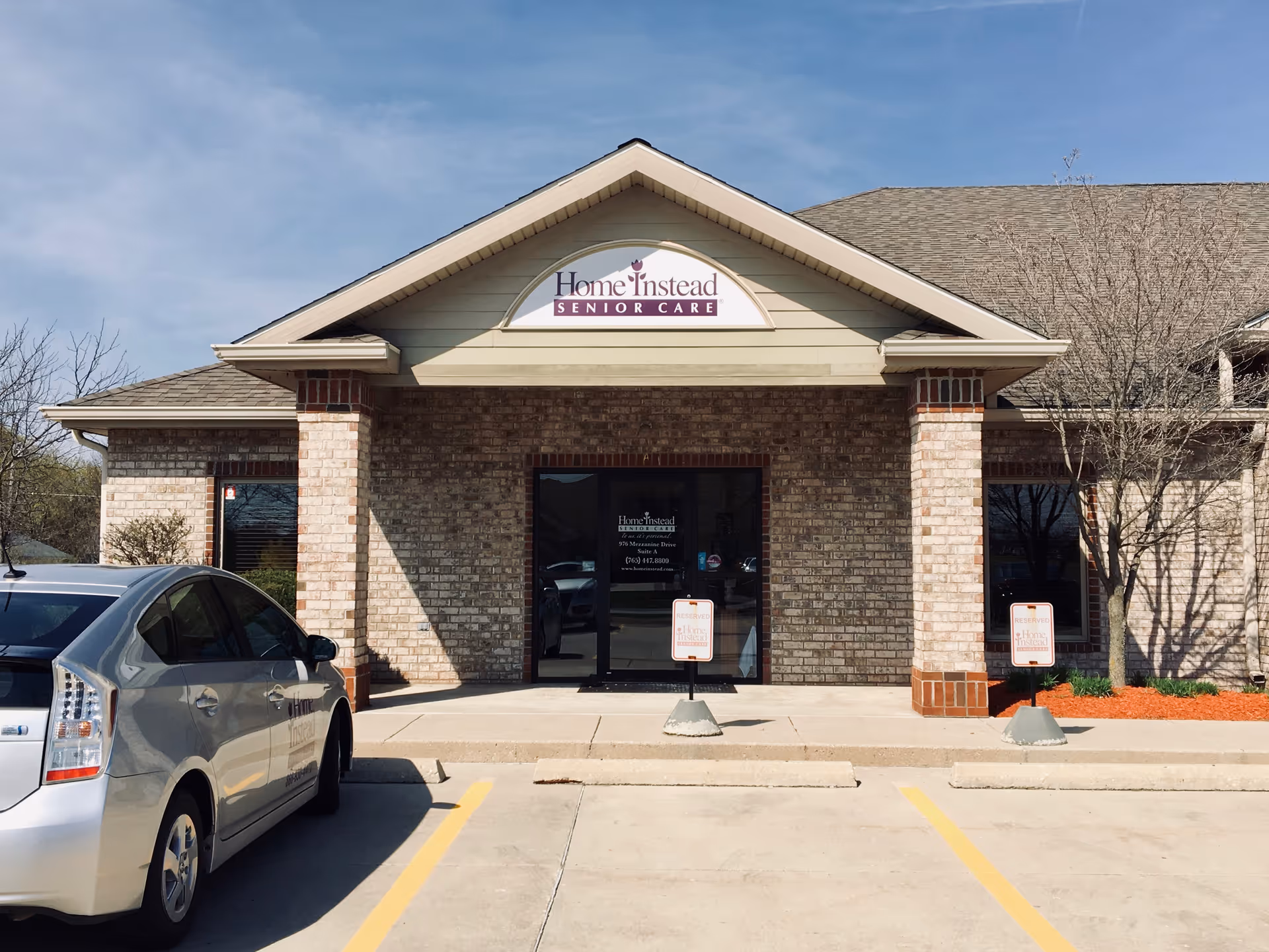 Front view of a Home Instead Senior Care building with a parked car.