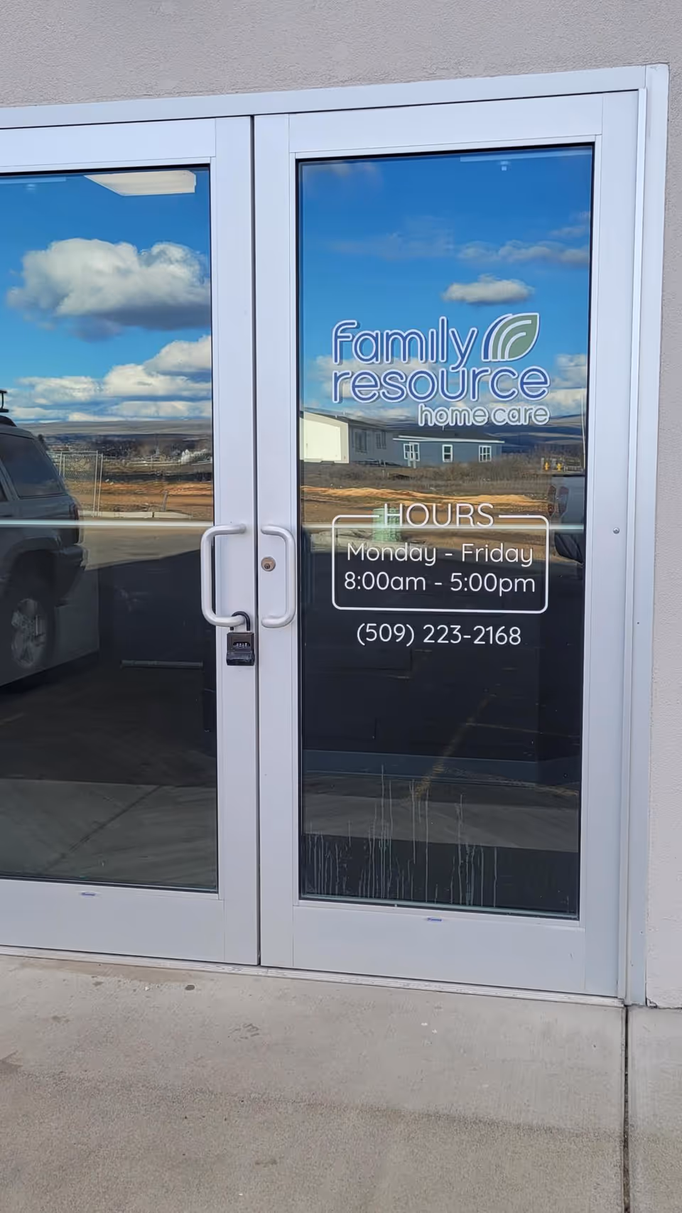 Glass exterior door with Family Resource Home Care logo, hours, and phone number.