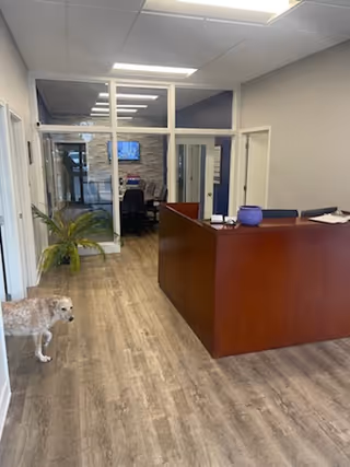 Reception desk in a hallway of a Senior Helpers facility with a dog nearby.