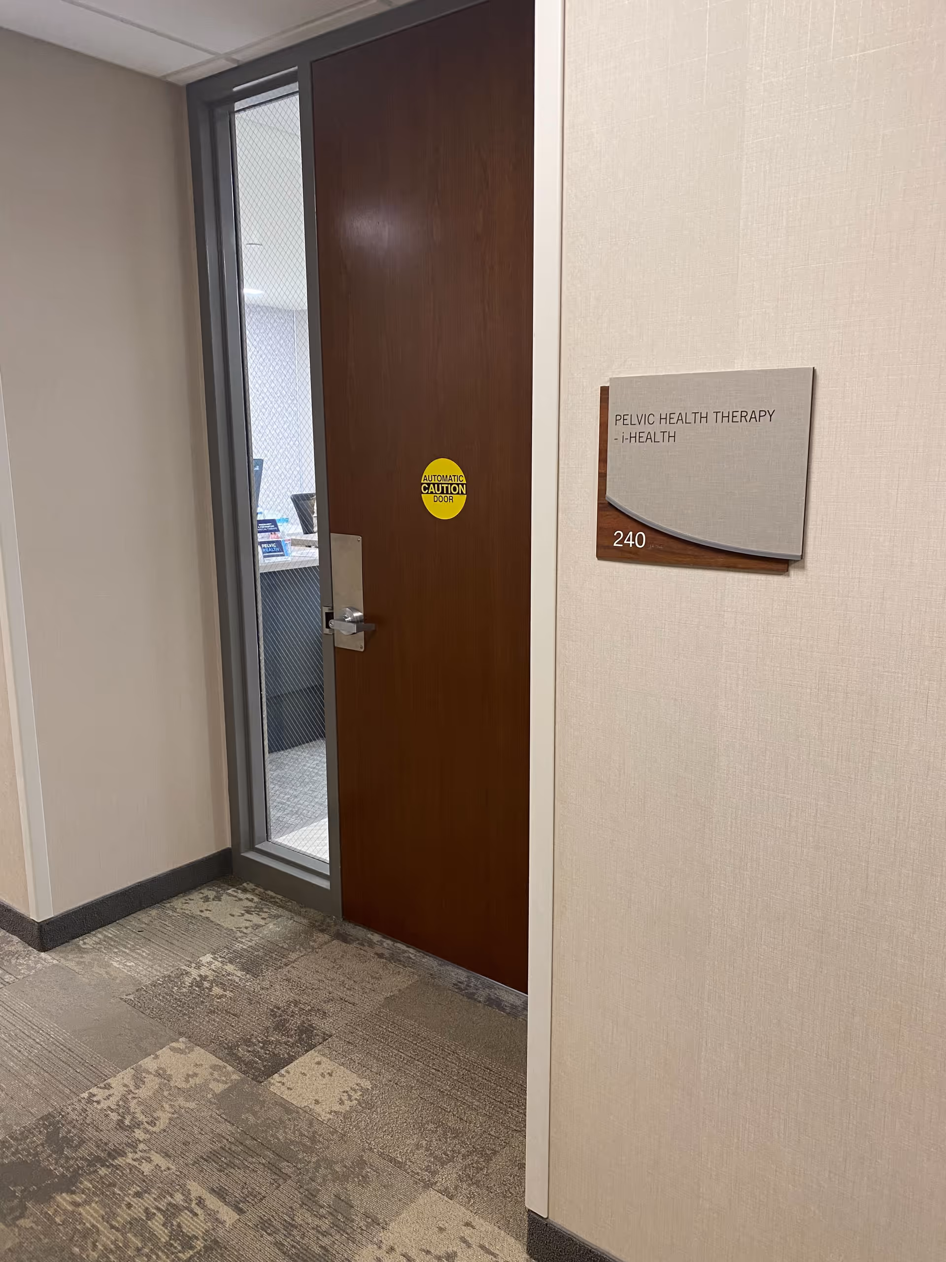 Interior hallway with a wooden door labeled Pelvic Health Therapy Edina, room 240.
