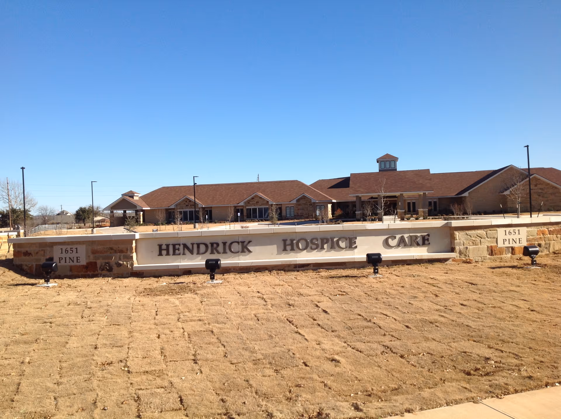 Exterior view of Hendrick Hospice Care with a stone sign in front