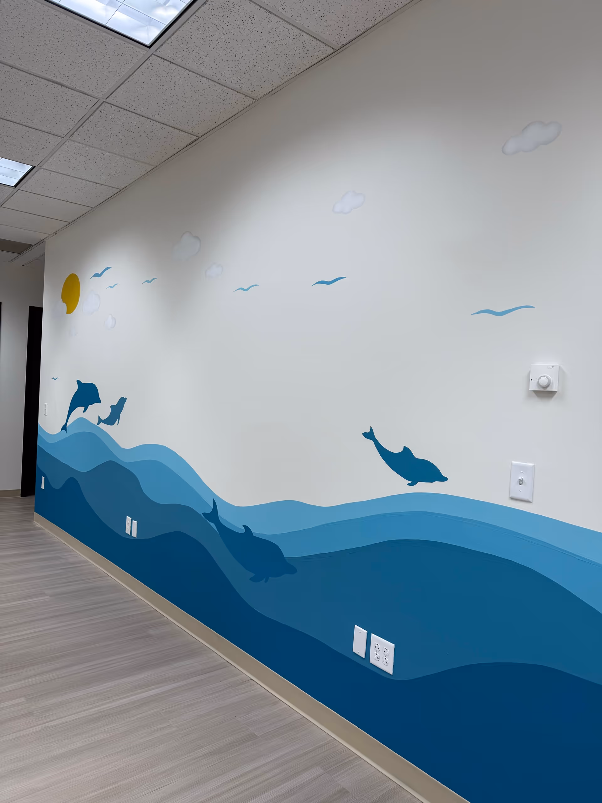 Interior hallway featuring a blue ocean wave mural along the wall.