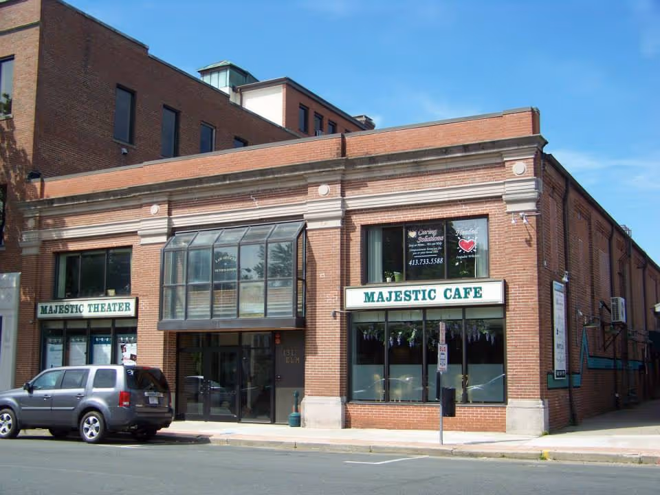 Brick building with Majestic Cafe and Majestic Theater storefronts on a city street.