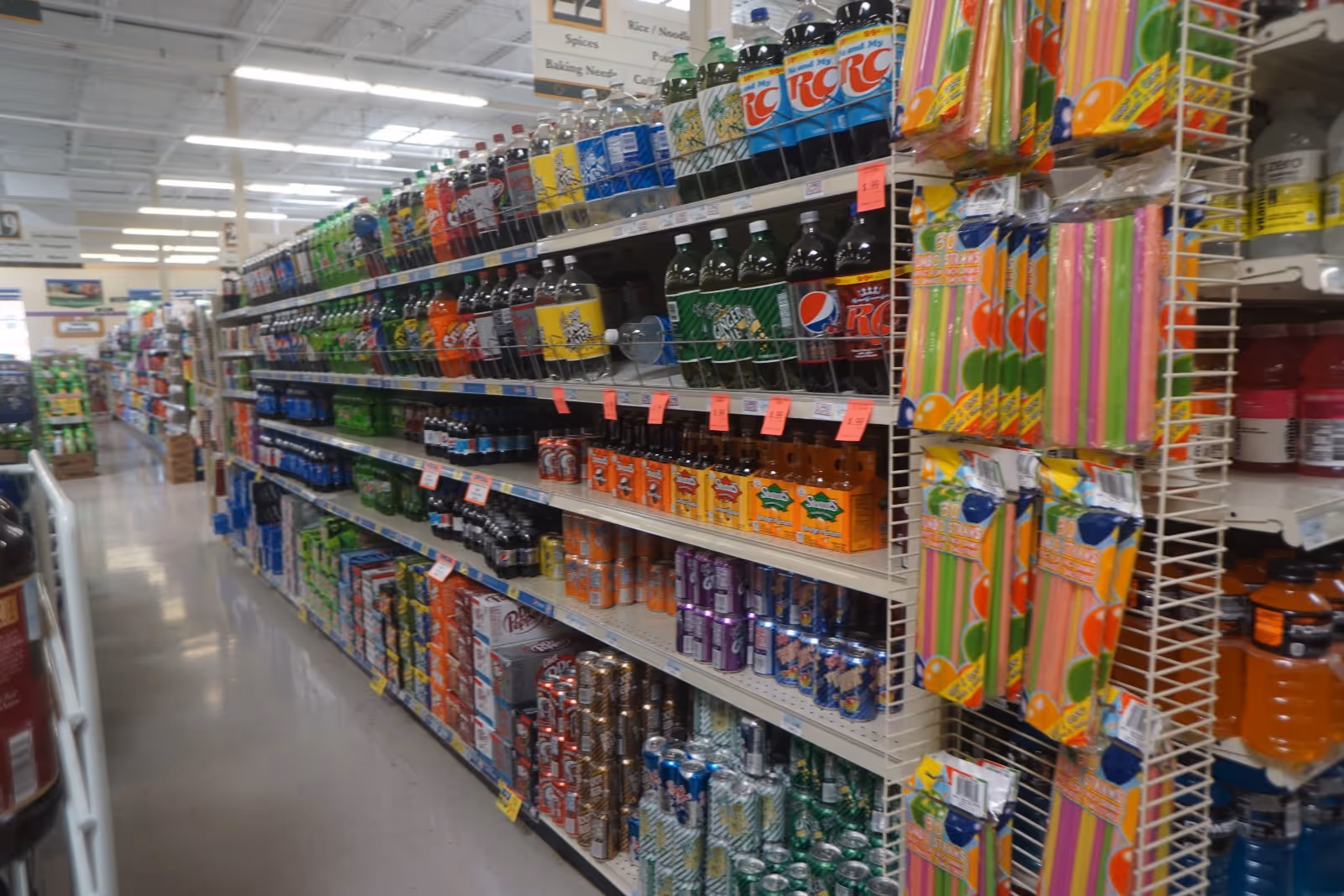 A grocery store aisle lined with shelves of sodas and beverages.