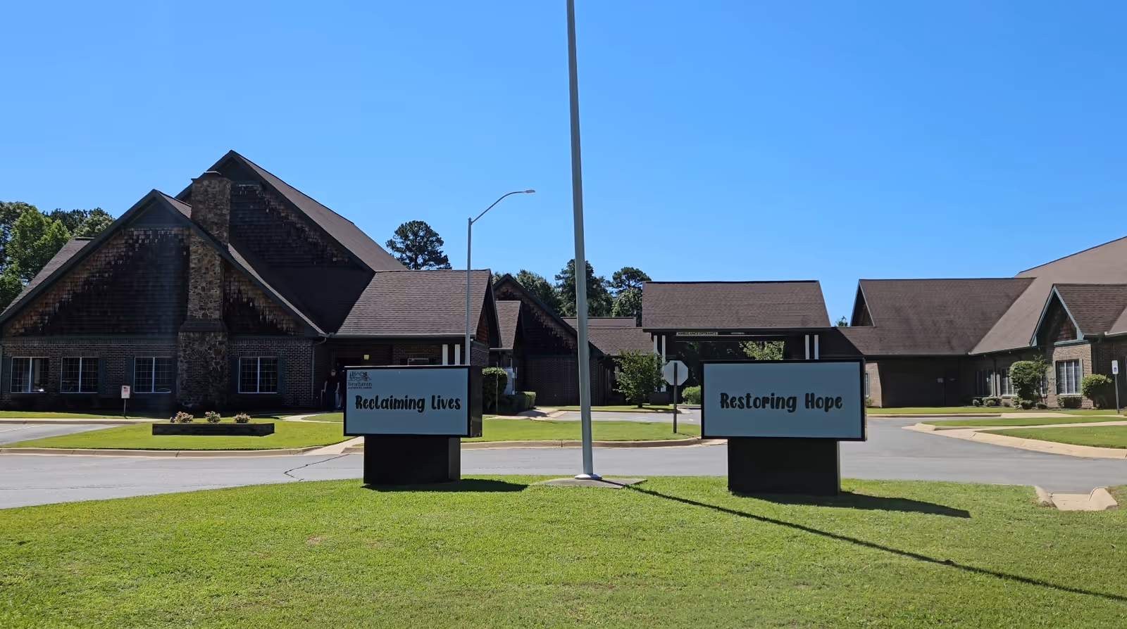 Exterior view of a hospice facility with lawn and signboards