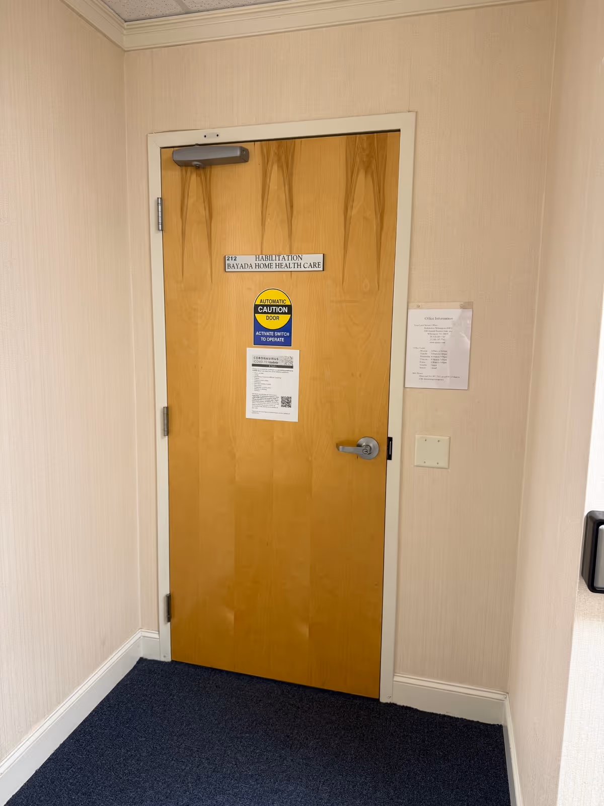 Wooden interior door in a hallway with BAYADA Home Health Care signage.