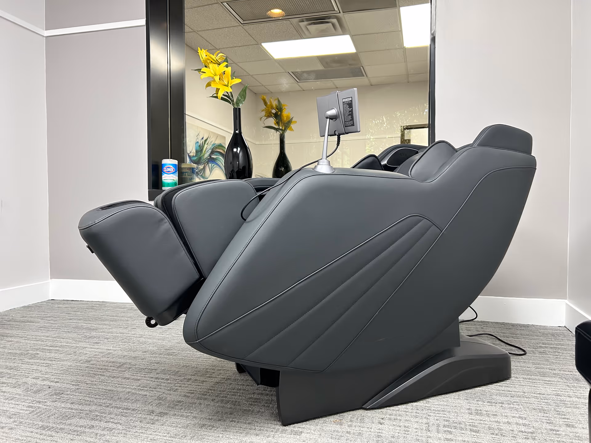 A gray reclining chair with a monitor in a modern interior room.