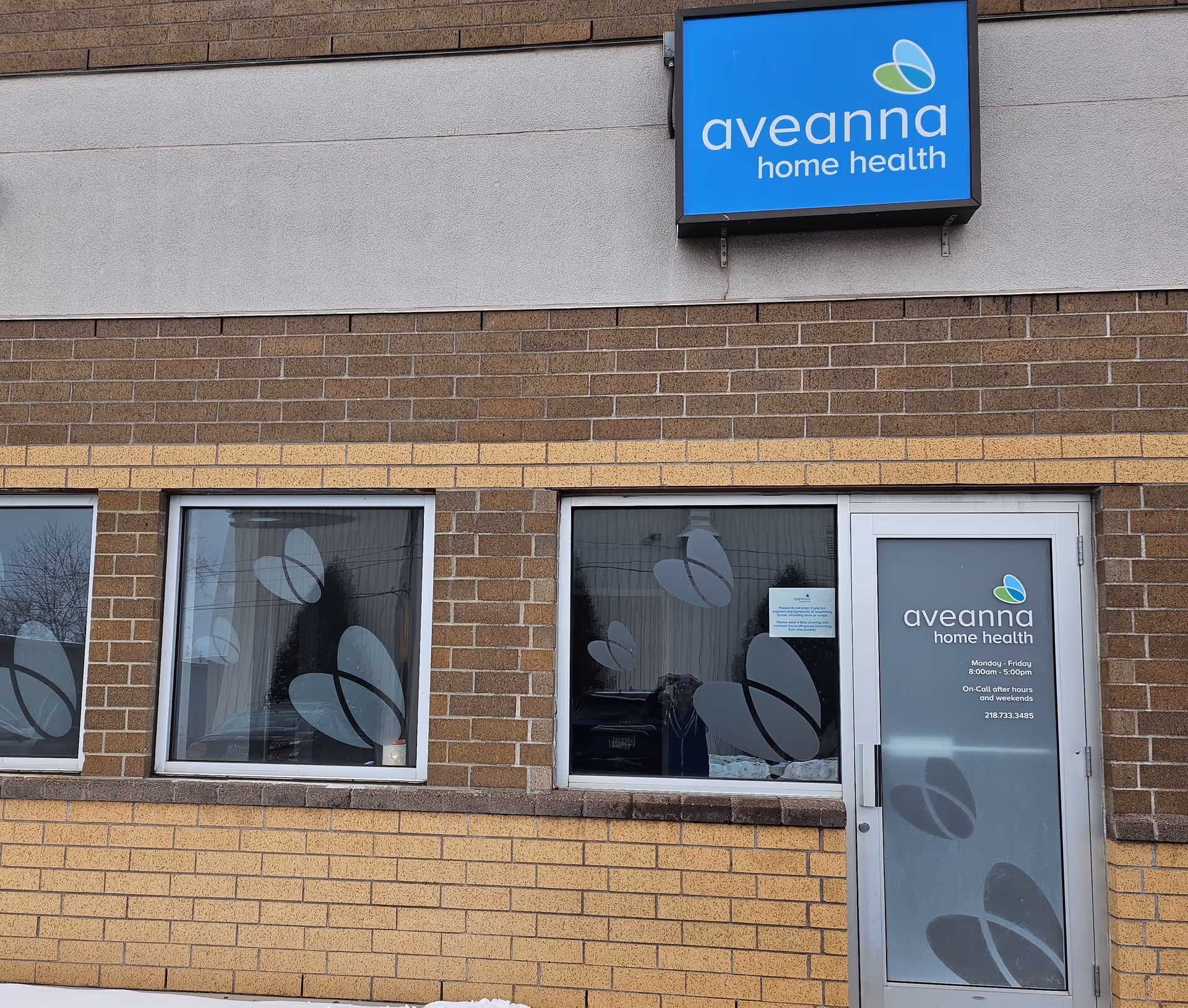 Exterior view of Aveanna Home Health building front with blue sign and glass door