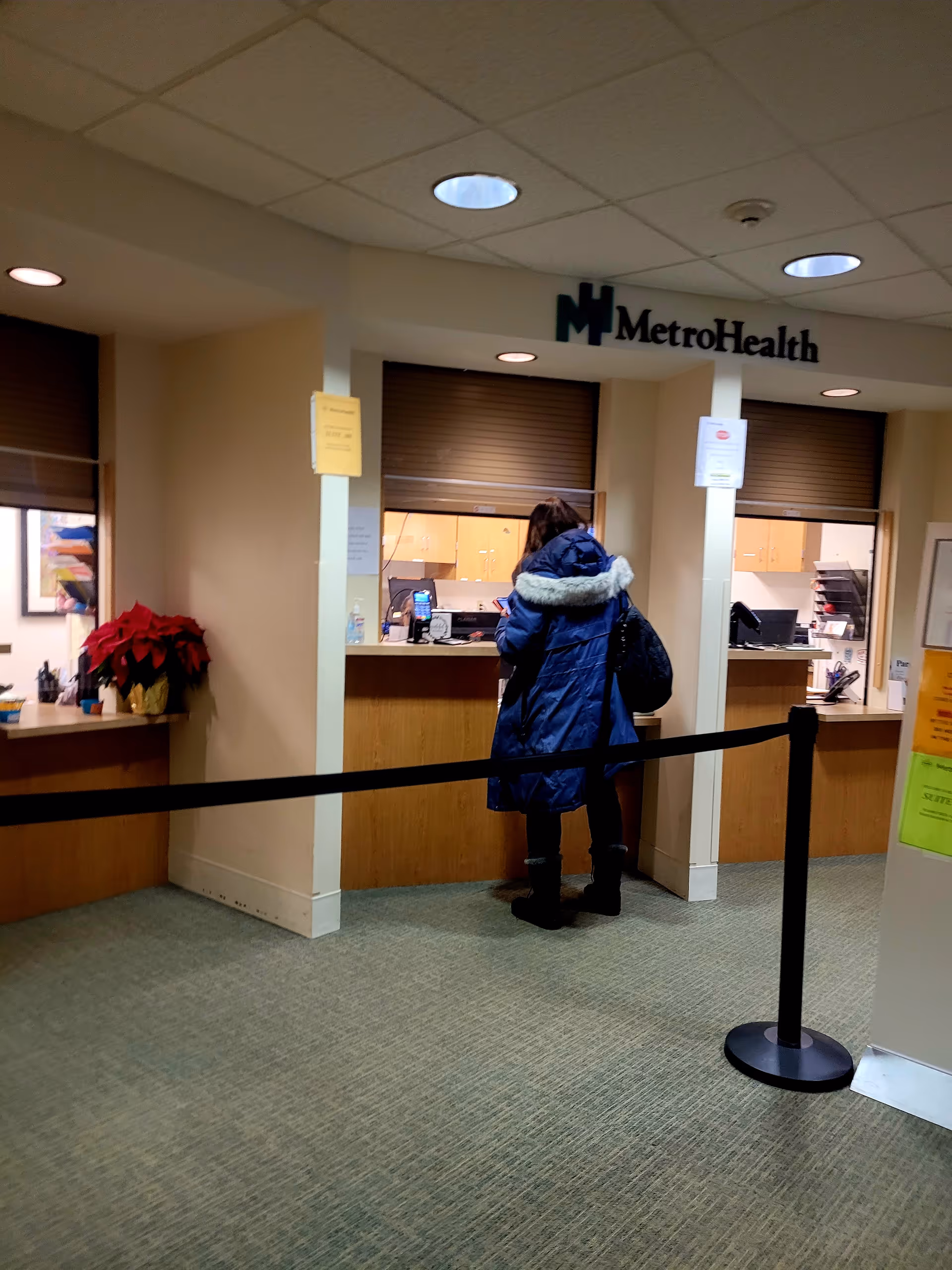 Inside MetroHealth Beachwood Health Center reception area with a counter and a standing visitor.
