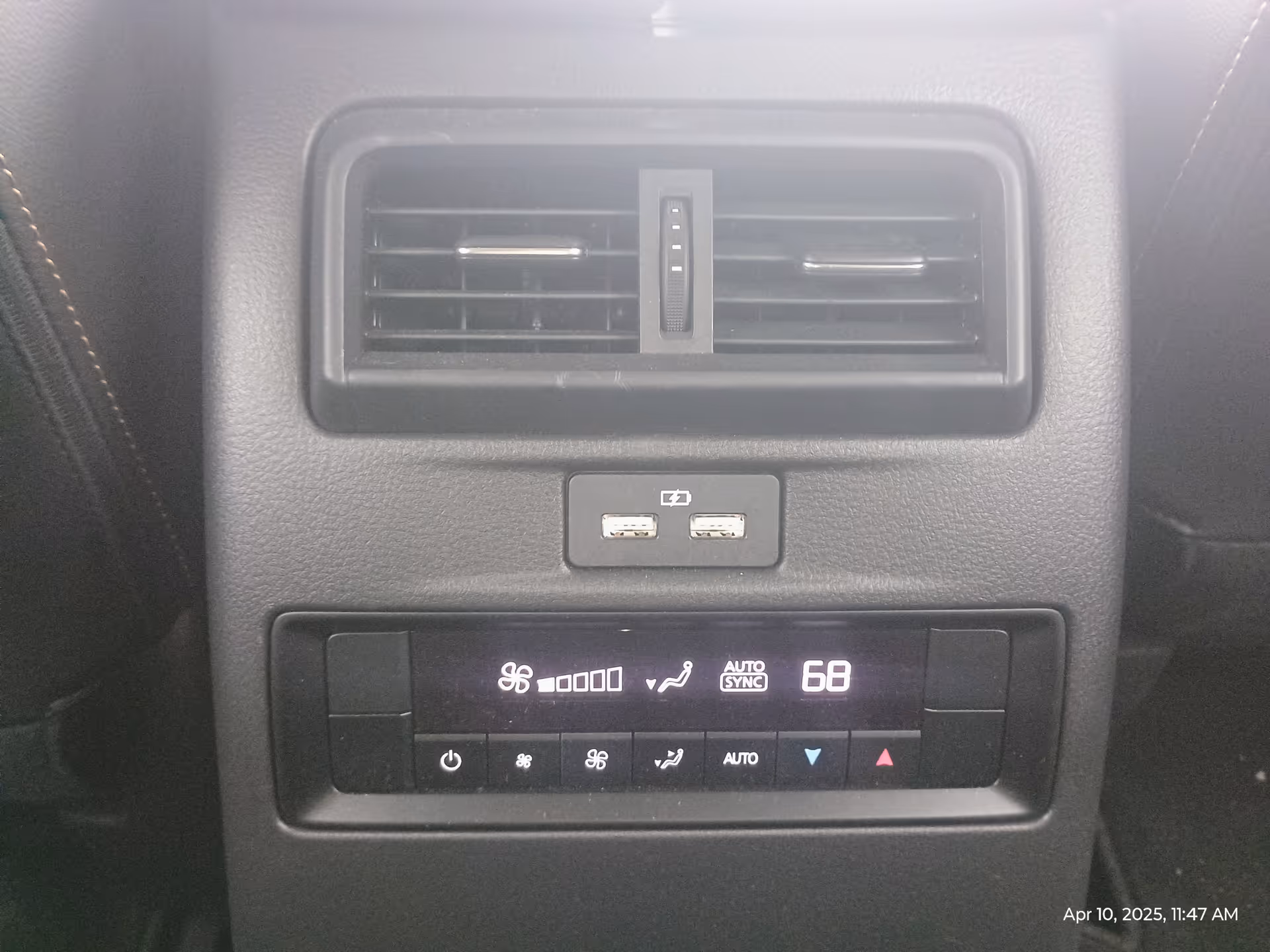 Close up of a car's rear climate control panel with vents and USB ports.
