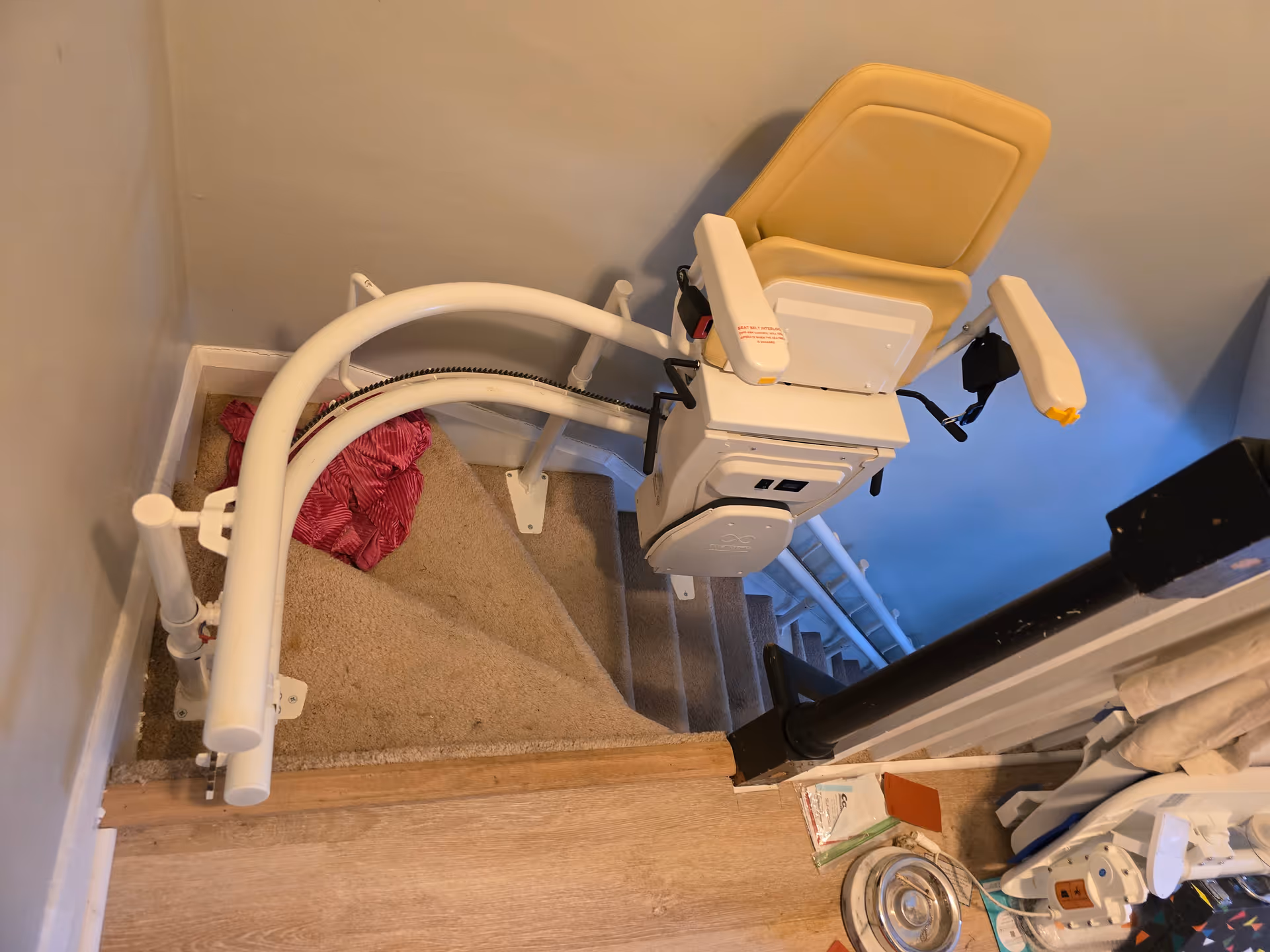 Interior stairwell featuring a beige powered chairlift for accessibility along the steps.