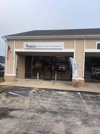 Front exterior of a Senior Helpers facility with glass entry doors and a parking area.