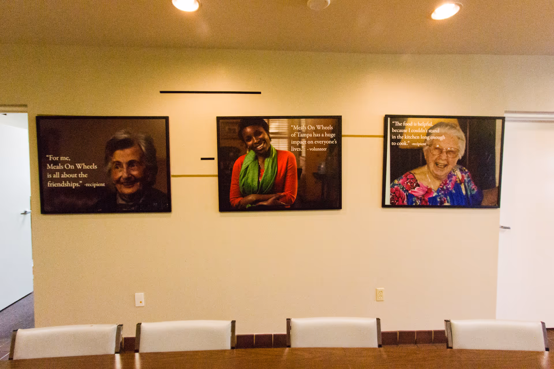 Conference room with three framed portraits and quotes along the wall.