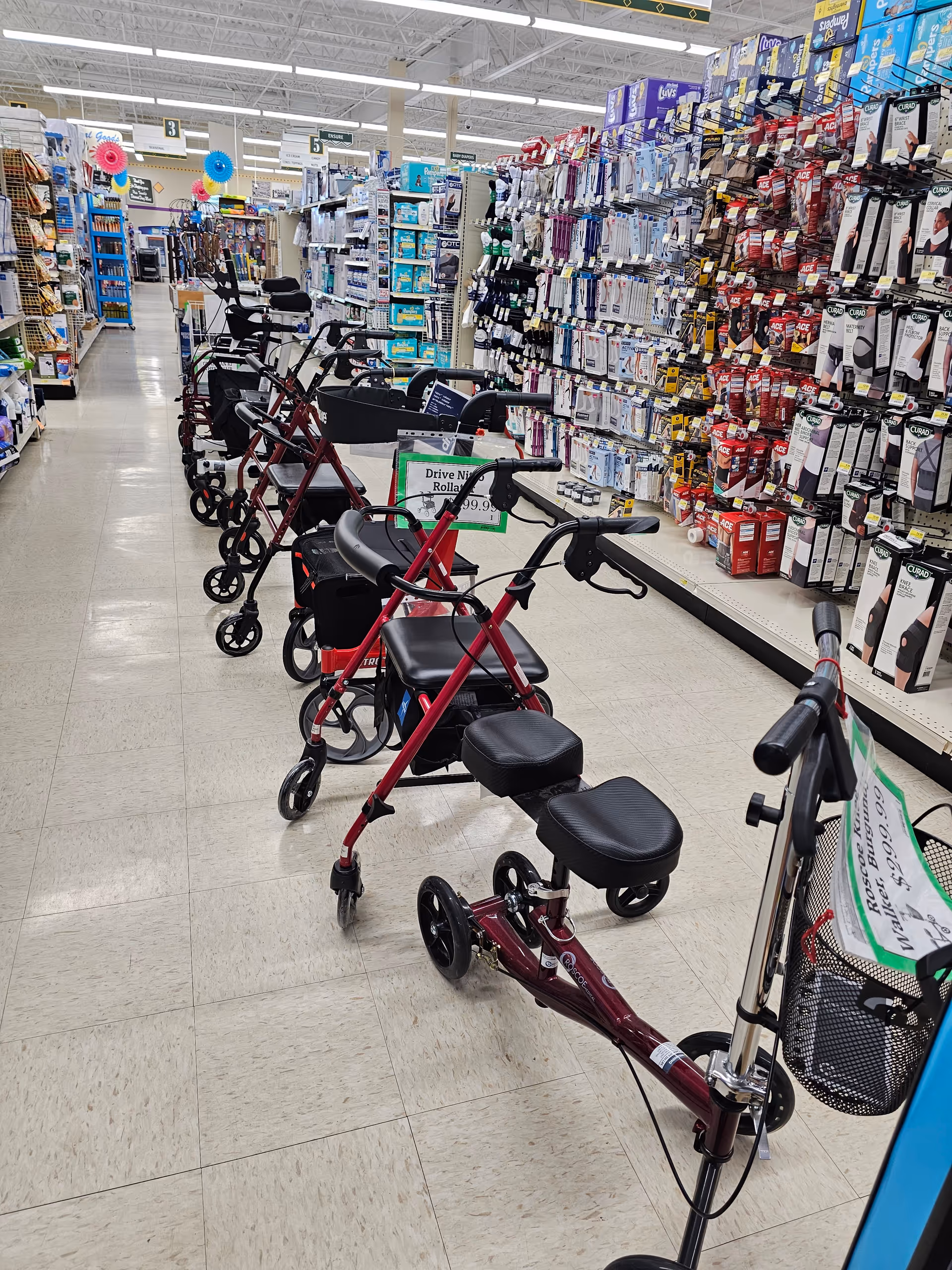 Aisle of Discount Drug Mart with several mobility scooters lined up near shelves.