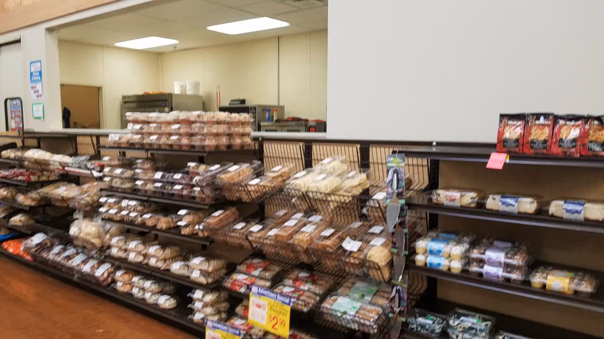 Interior view of a Discount Drug Mart bakery aisle with bread and pastries on shelves.