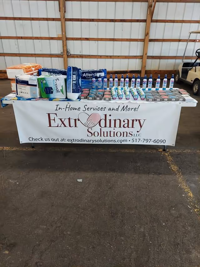 Table with assorted in-home care supplies and a banner reading Extraordinary Solutions LLC