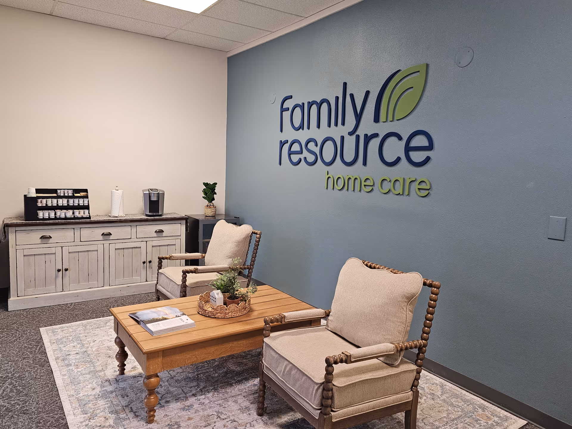 Reception area with blue wall displaying Family Resource Home Care logo and seating.