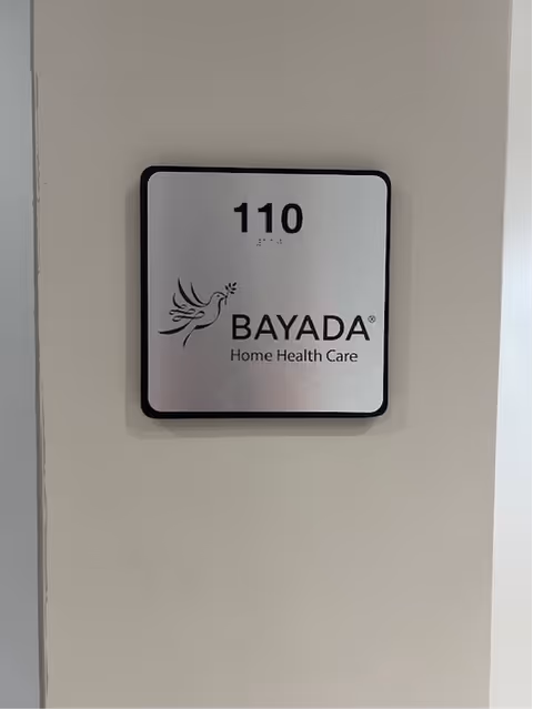 Interior wall plaque displaying room number 110 and BAYADA Home Health Care logo.