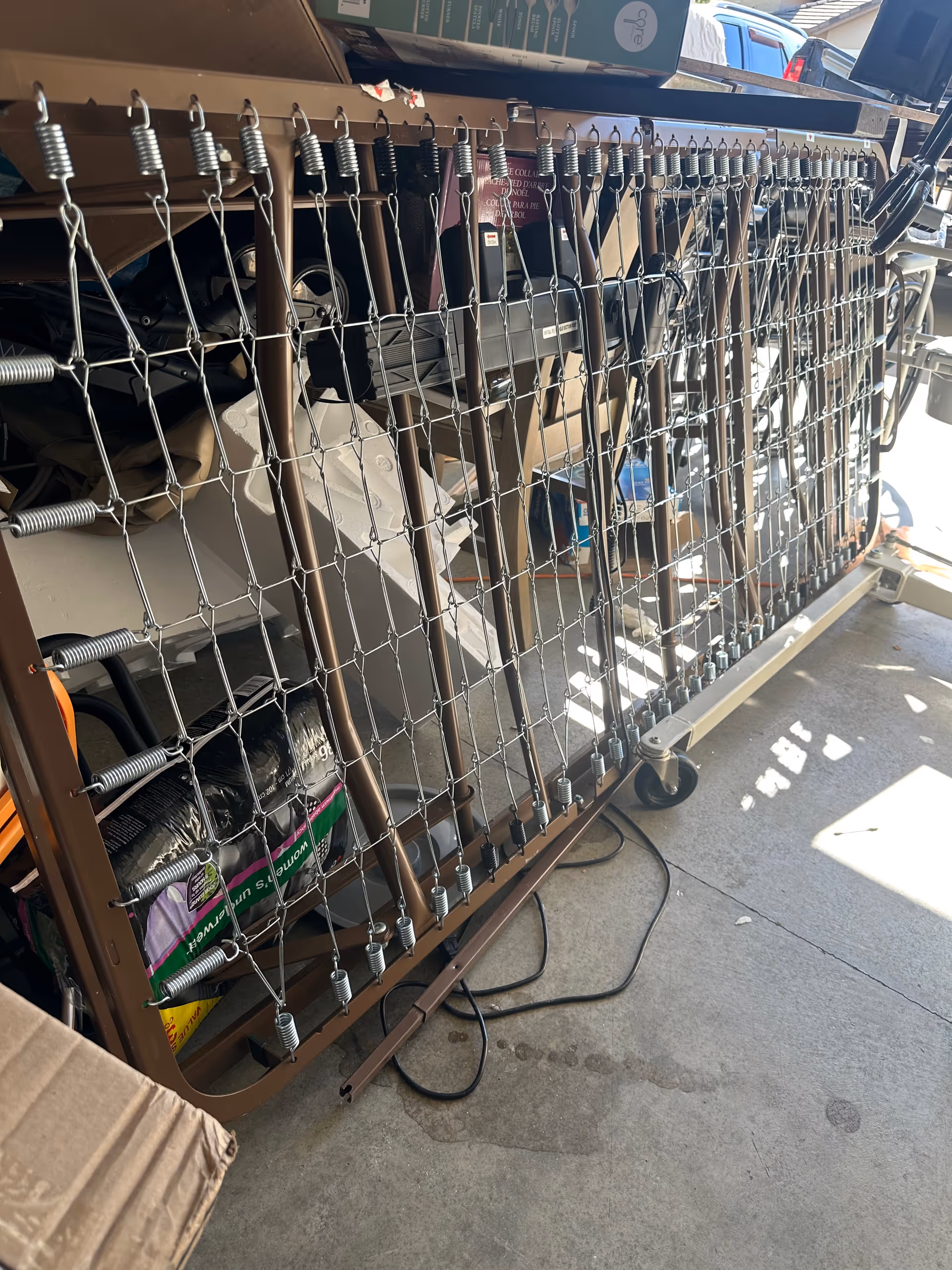 Interior storage area with a metal hospital bed frame and scattered boxes.