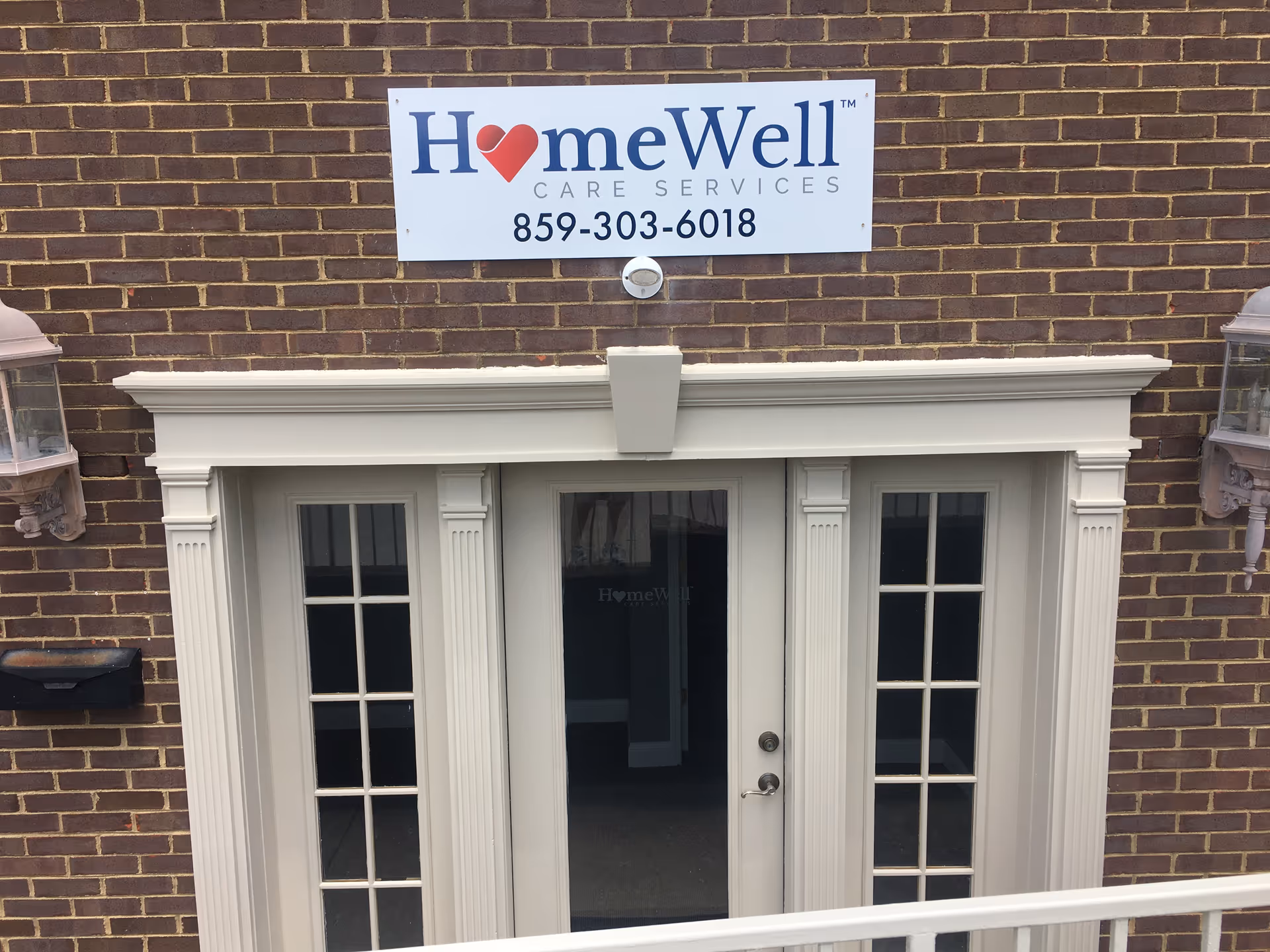 Brick building facade with a sign reading HomeWell Care Services above double doors