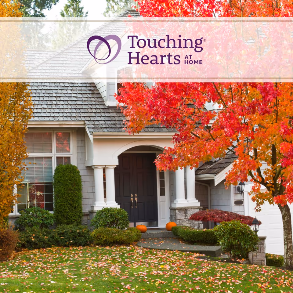 Front entrance of a home-like facility with fall foliage and pumpkins.