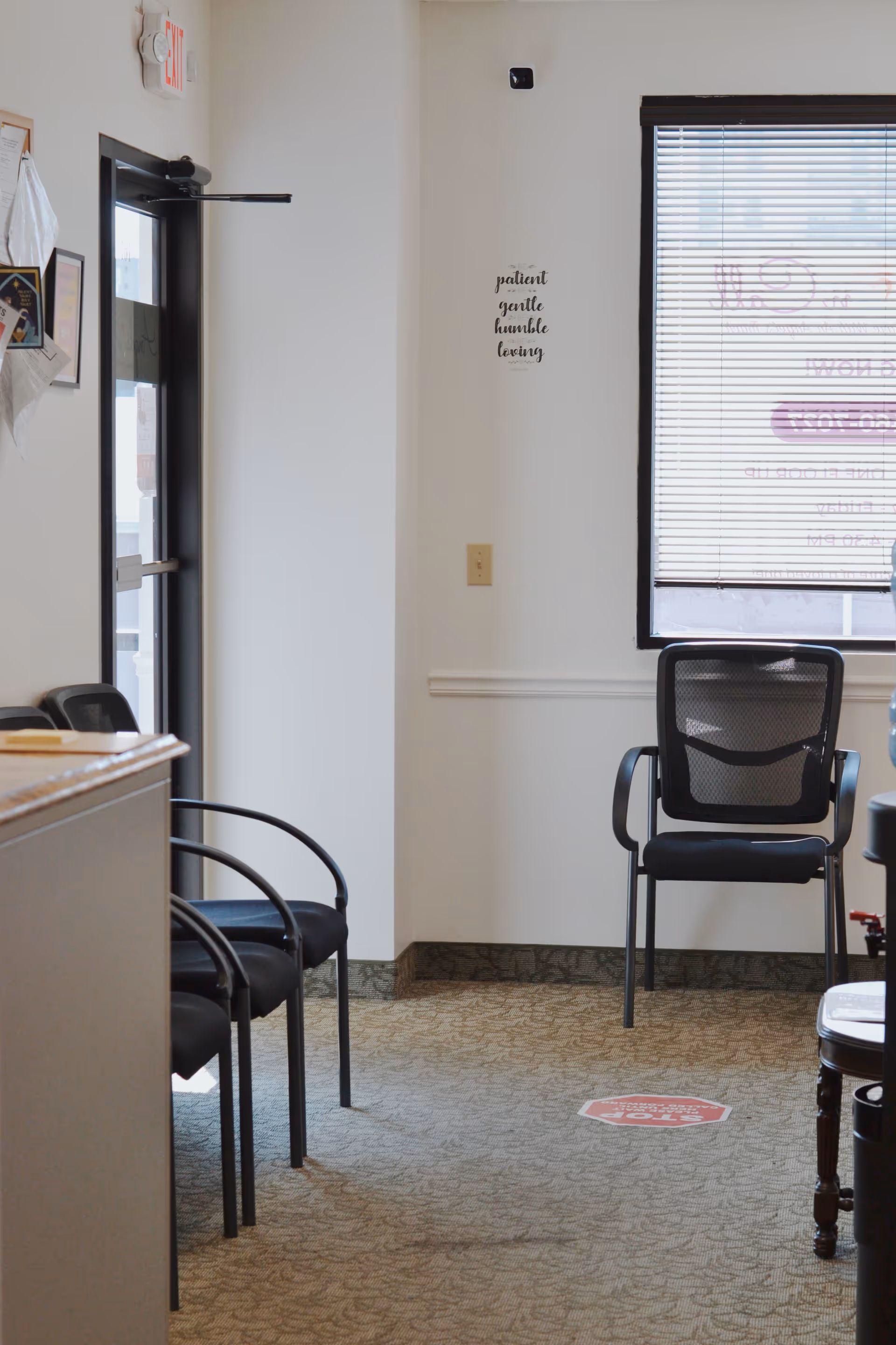 Waiting area of Angels On Call Home Care with chairs, window blinds, and wall art.