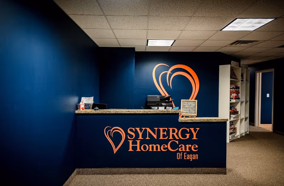 Reception desk in a Synergy HomeCare lobby with a heart logo.