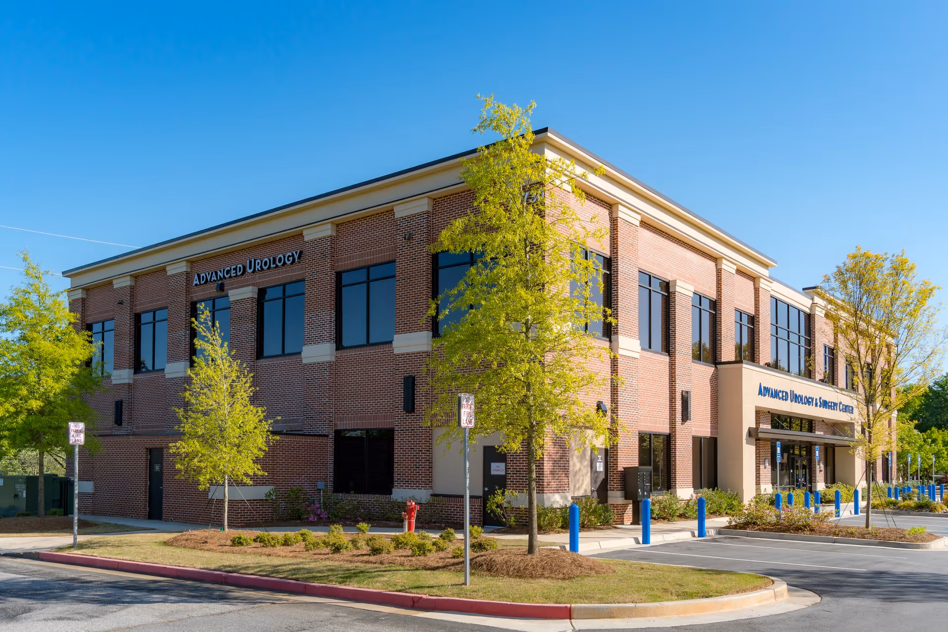 Exterior view of a brick medical building with large windows and a parking lot.