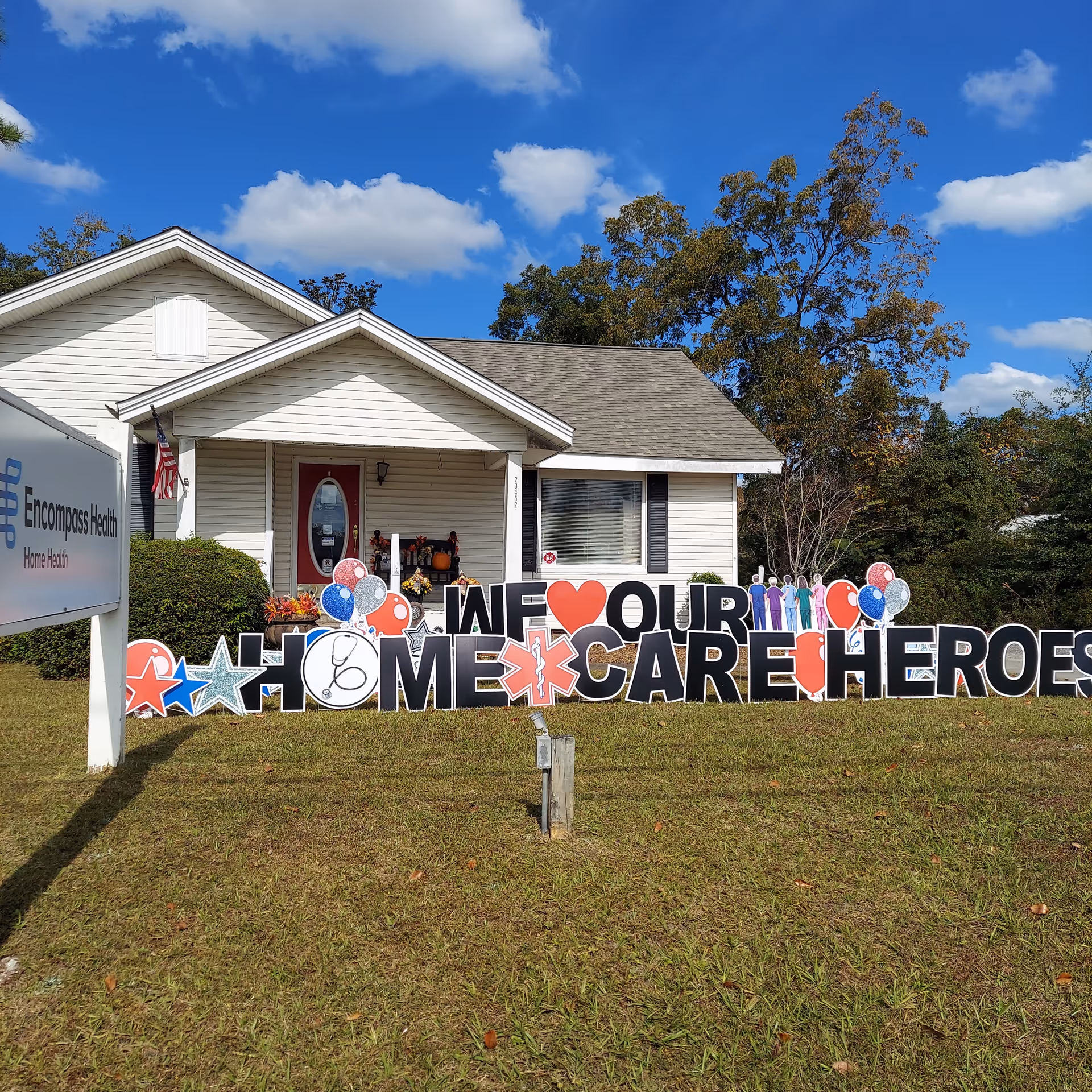 White one-story building with front porch and large HOME CARE HEROES sign.