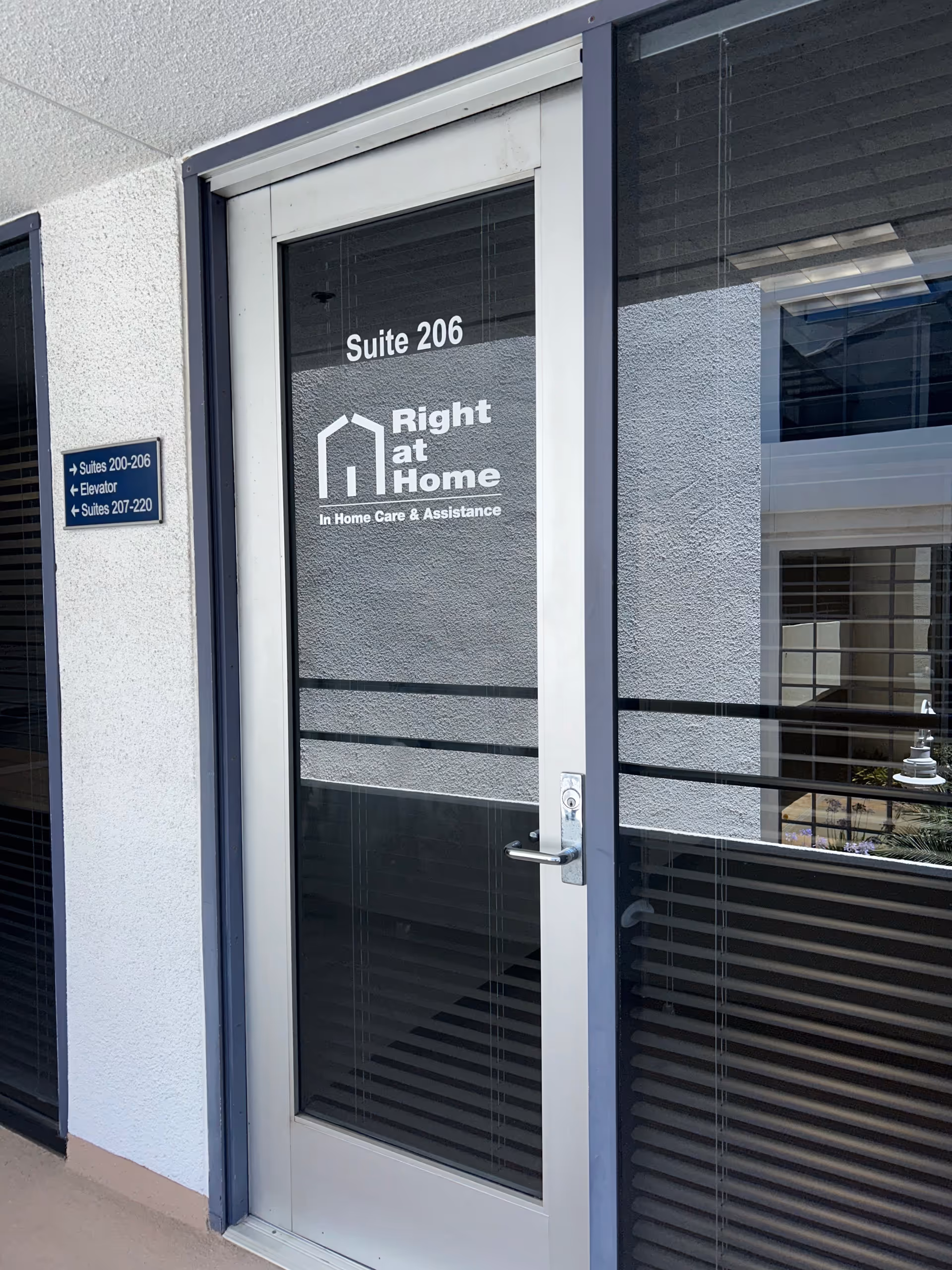 Glass door displaying Right at Home logo and Suite 206 at exterior entrance.
