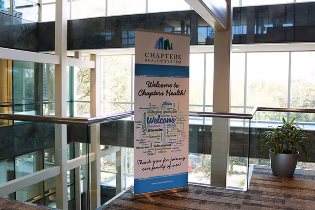 Interior atrium with a Chapters Health System welcome banner beside a plant.