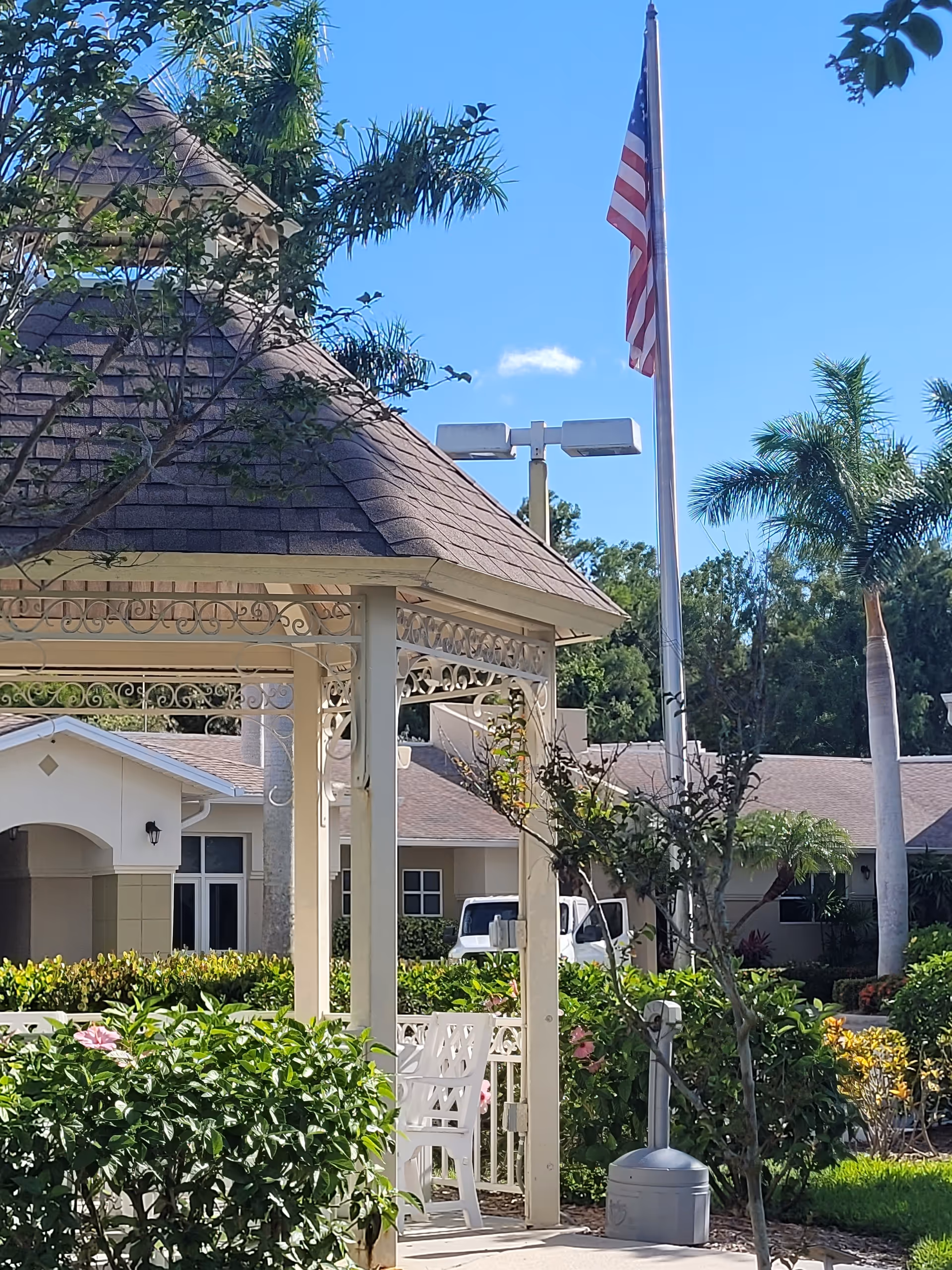Exterior view of Hope Hospice facility with gazebo, flagpole, and landscaped garden.
