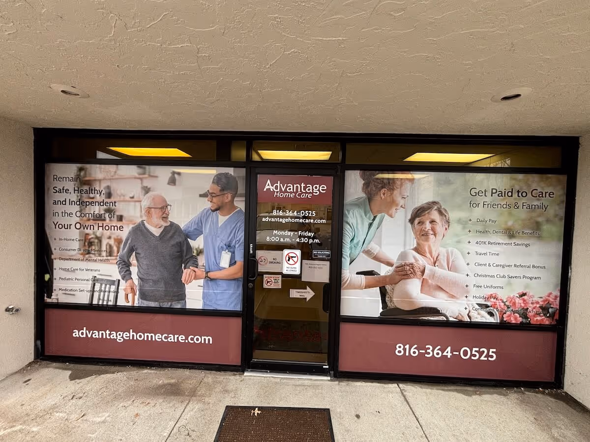 Storefront windows advertise Advantage Home Care with smiling staff and elderly clients.