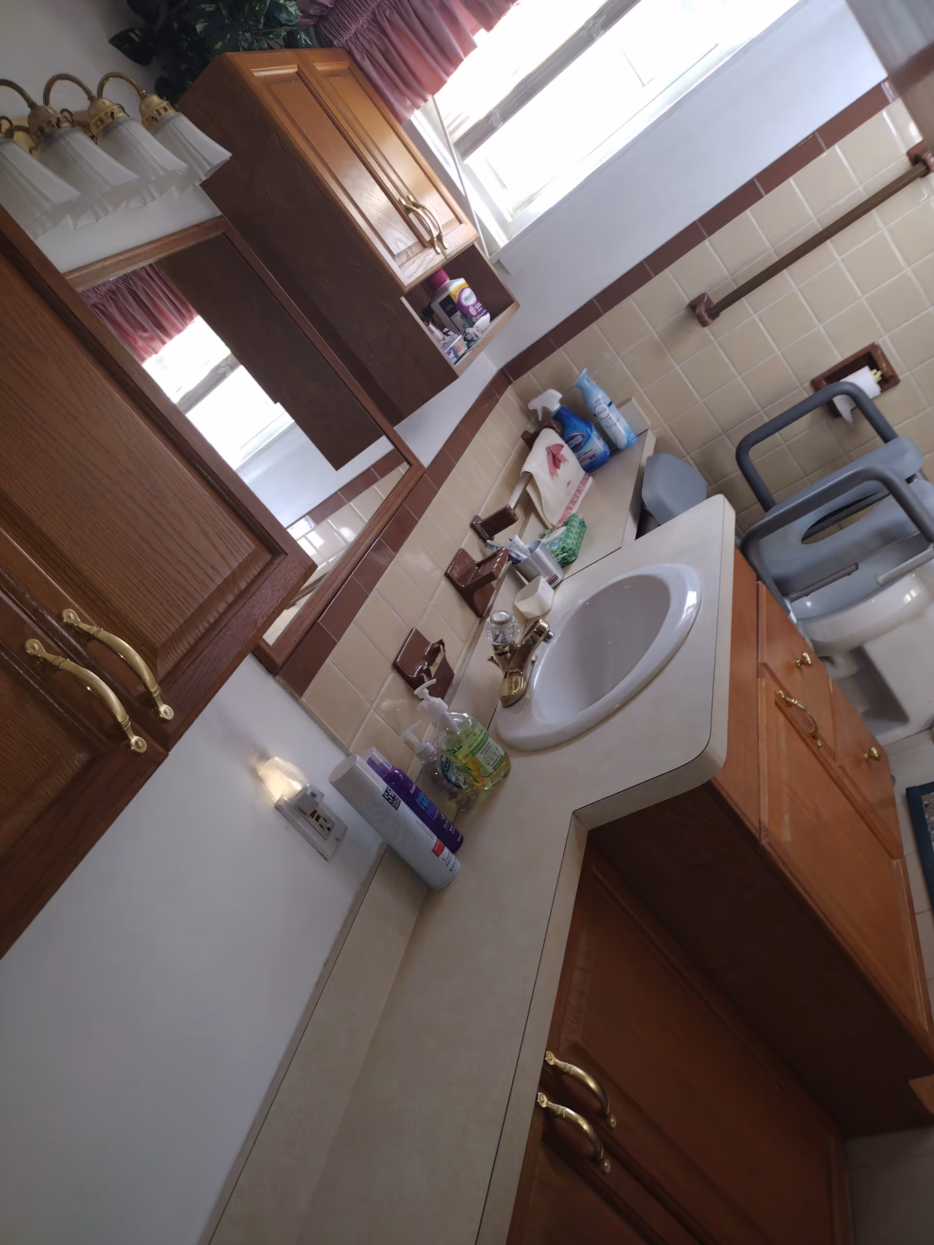 Bathroom vanity with sink, cabinets, and toiletries in a senior facility.